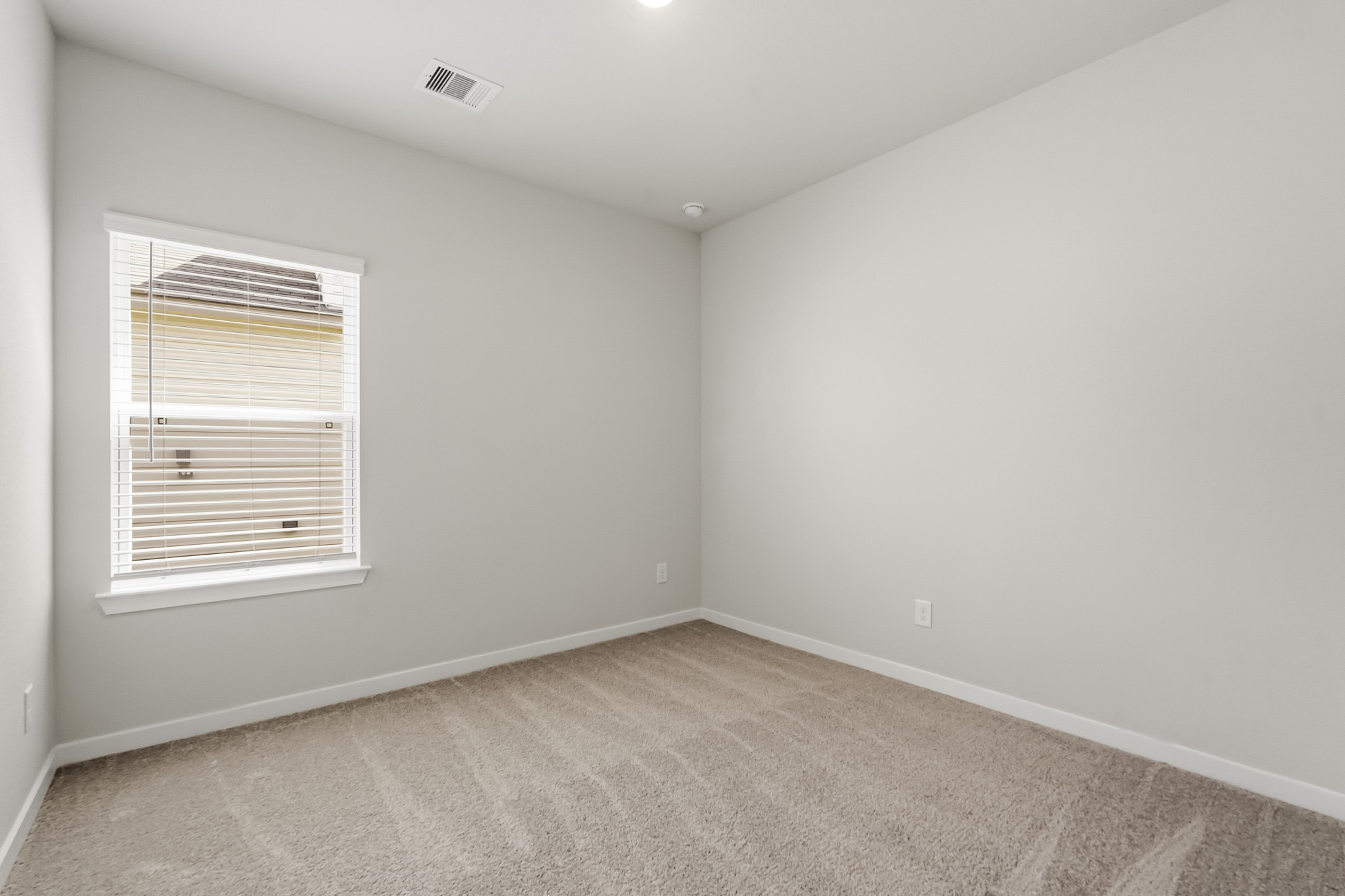A room with a window and carpet.