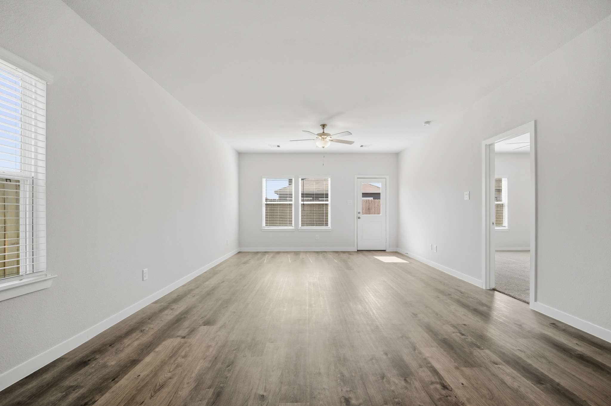 A room with a wood floor and a ceiling fan.