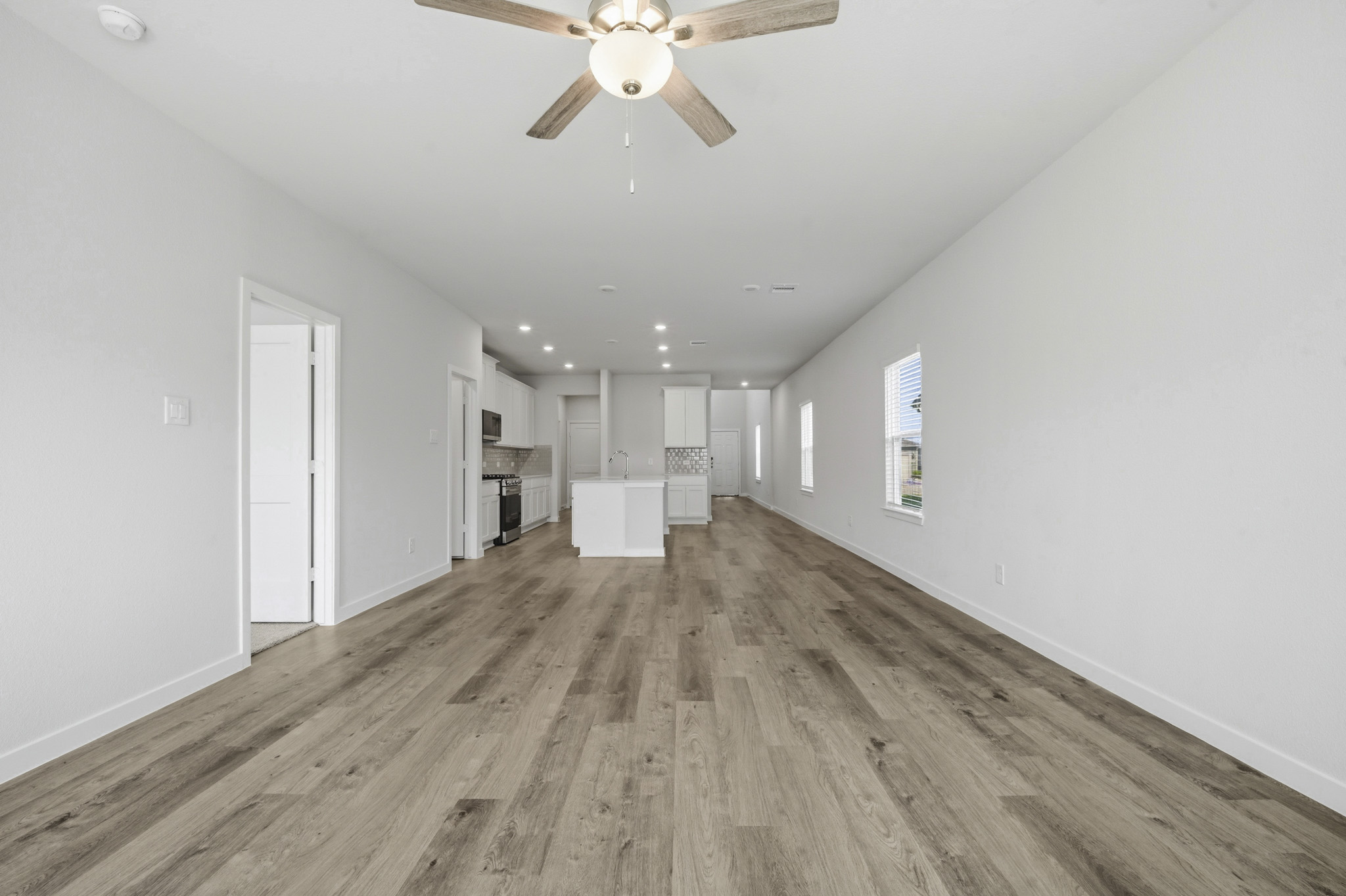 A room with a wood floor and a ceiling fan.