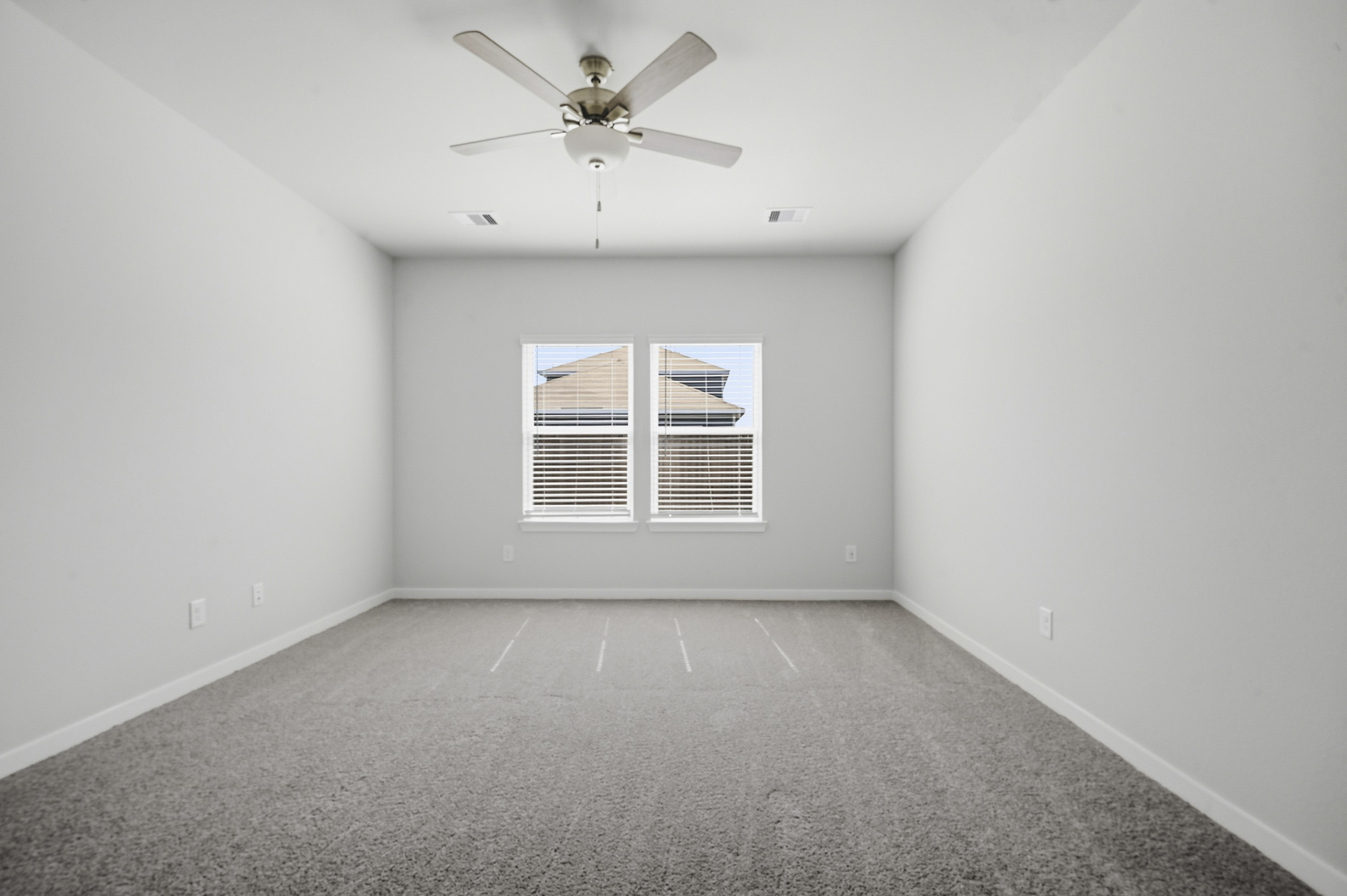 A room with a ceiling fan and a window.