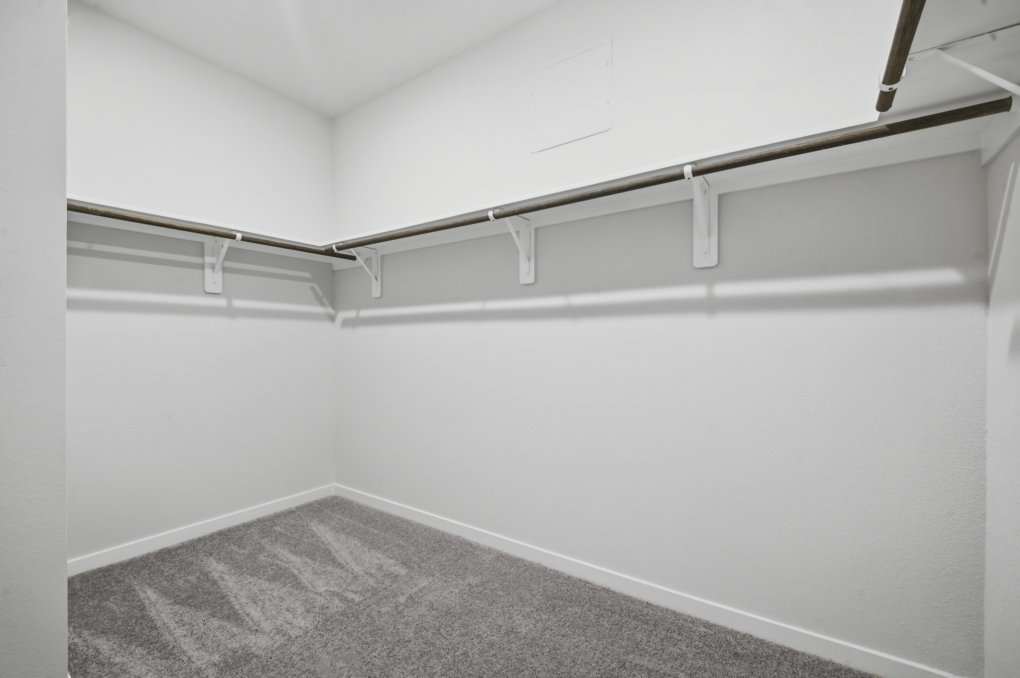A white wall with a grey carpet.