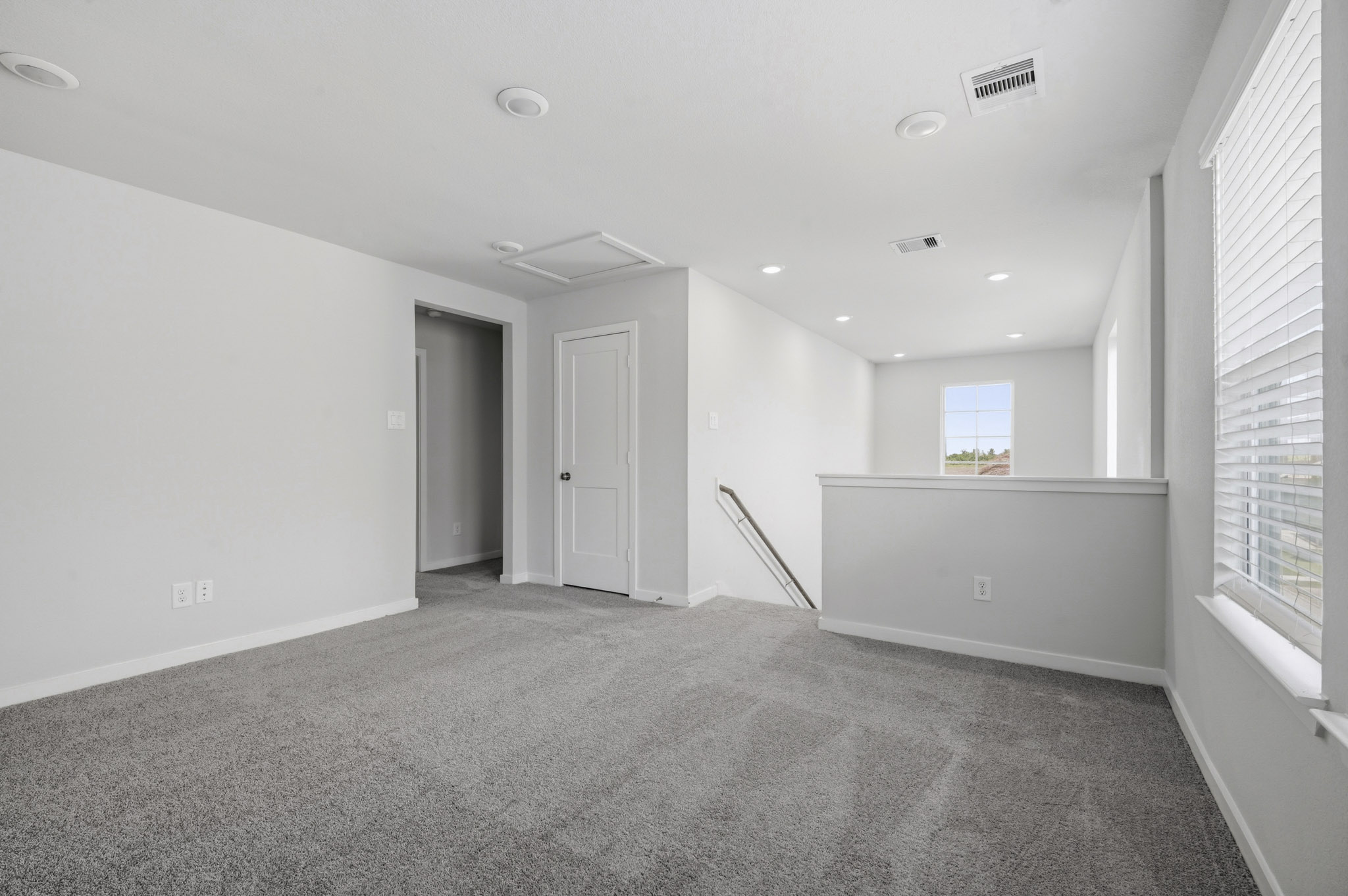 A room with a carpet and a door.