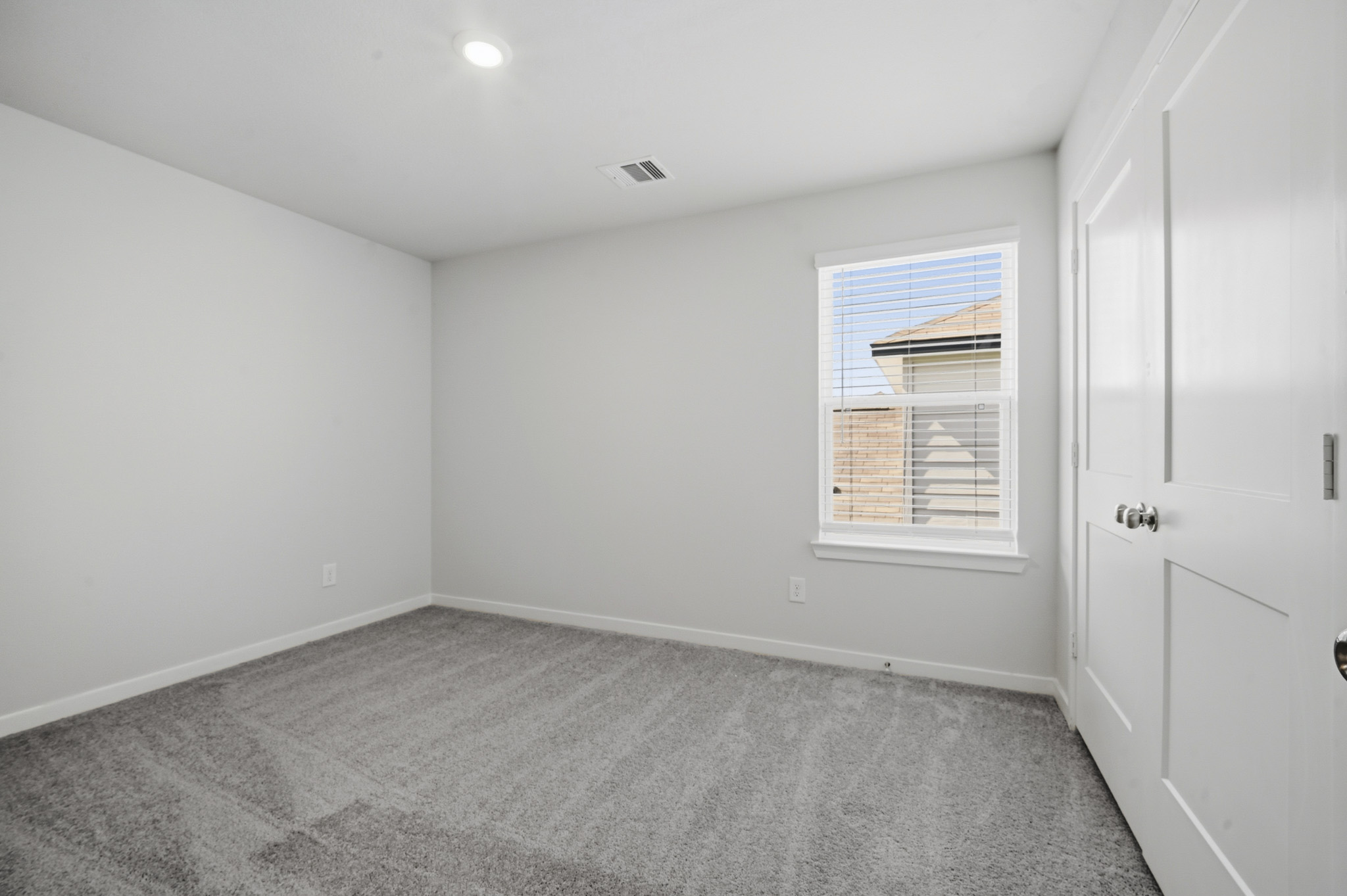 A room with white walls and a window.