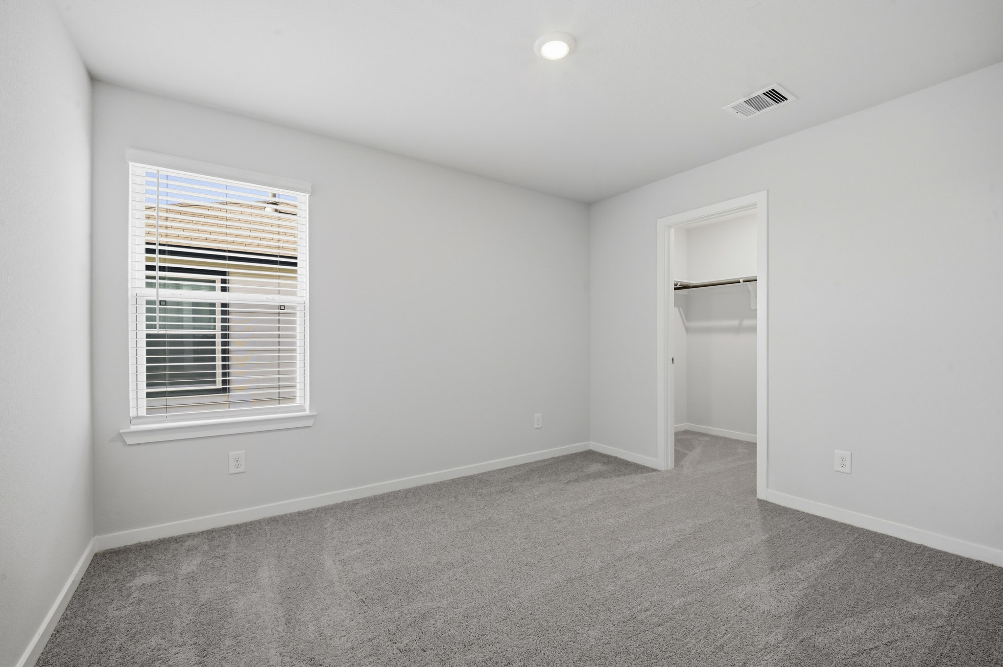 A room with a window and a shelf.