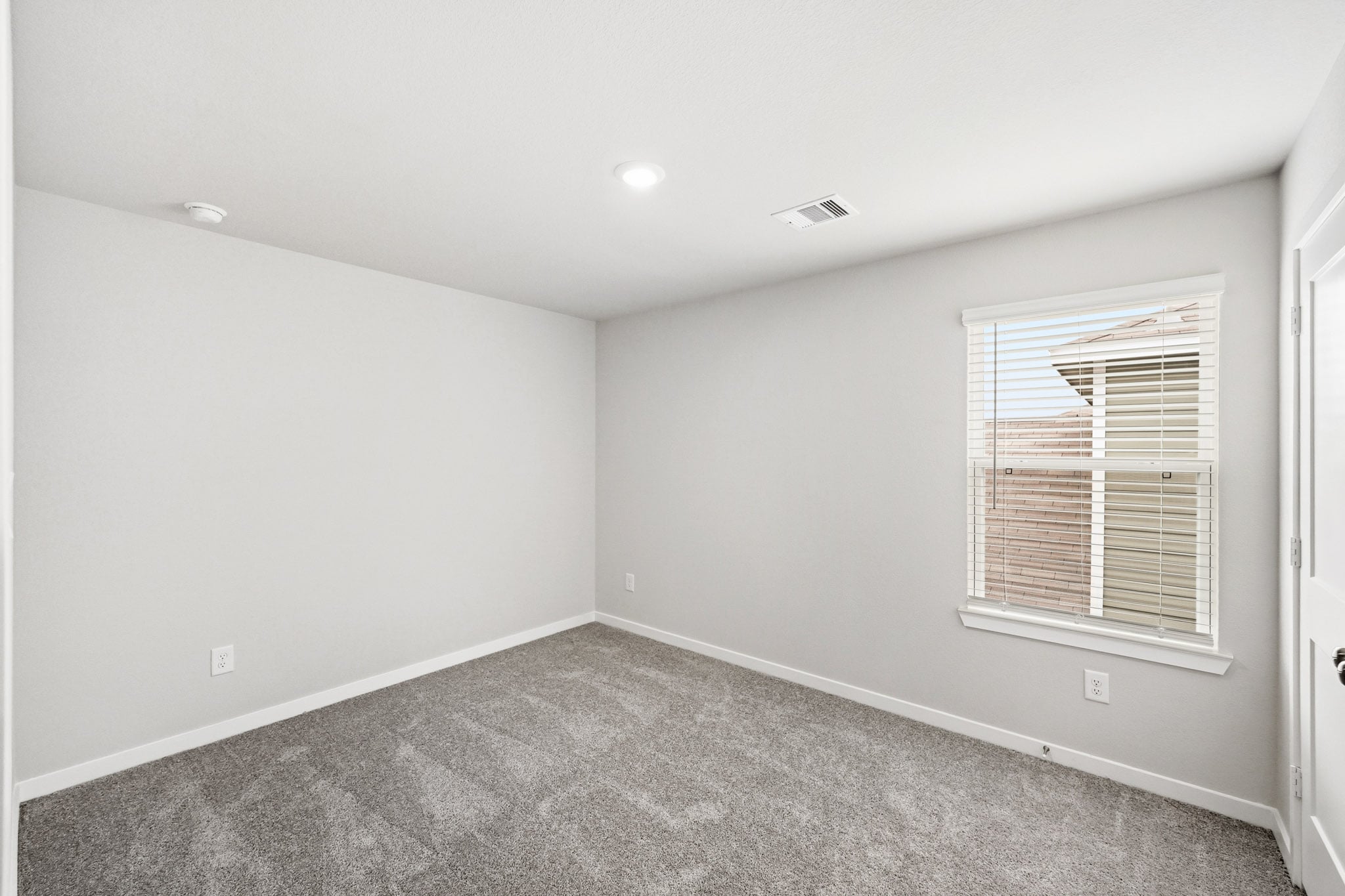 A room with a carpet and a window.