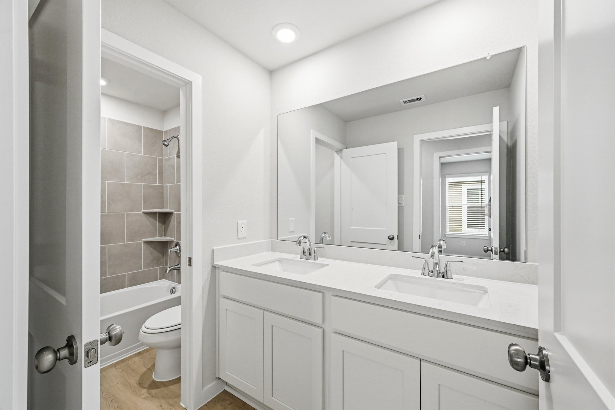 A bathroom with a sink toilet and mirror.