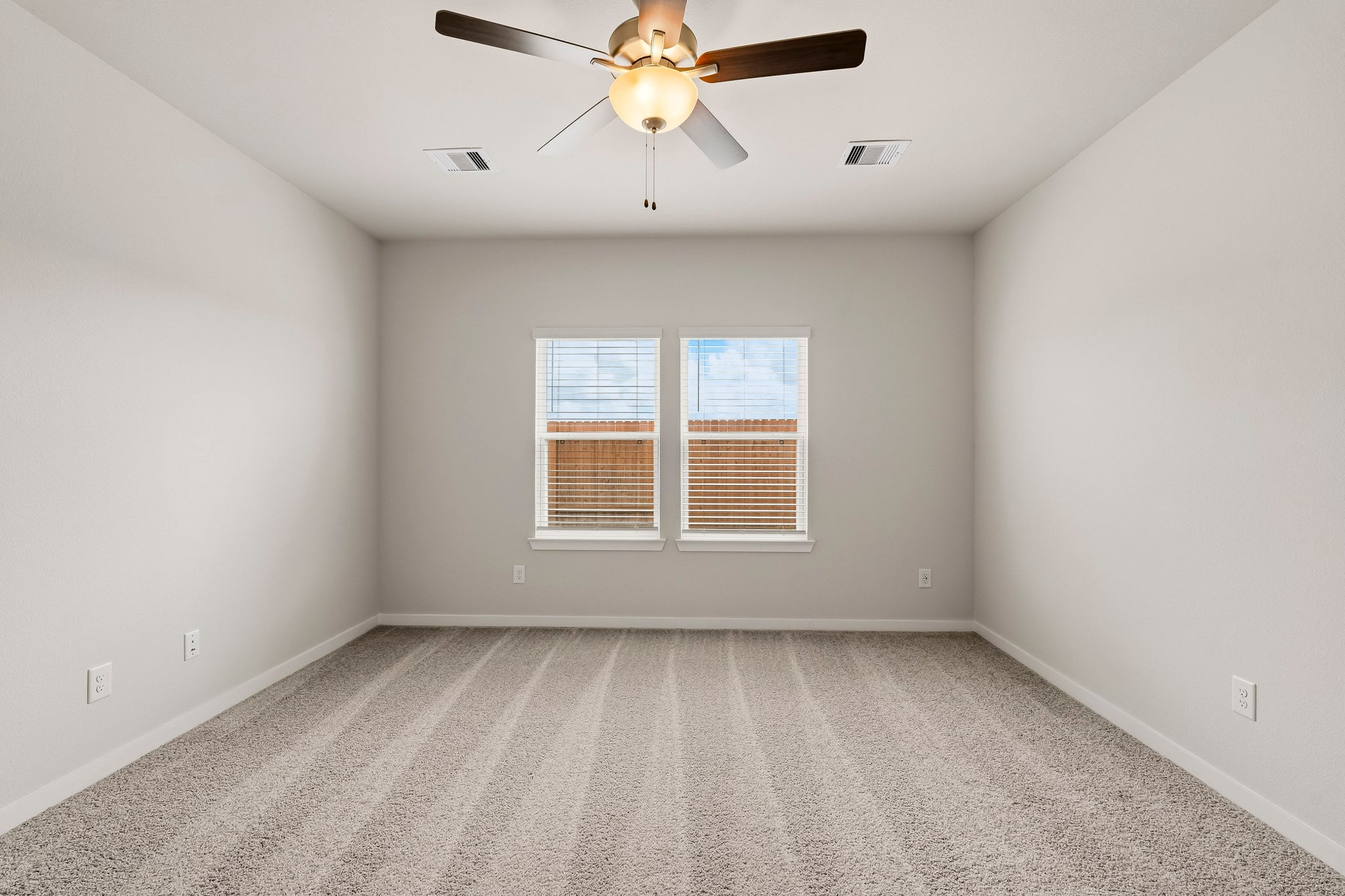 A room with a ceiling fan and a window.