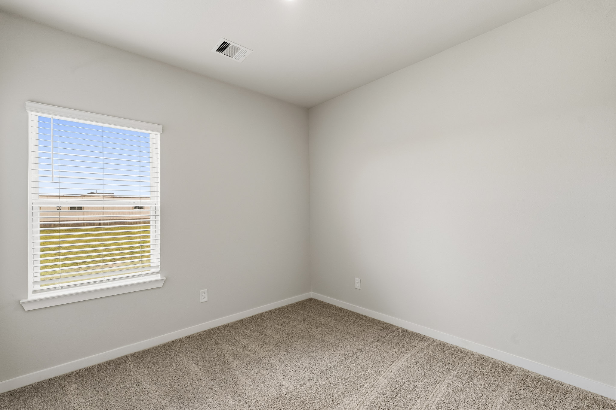 A room with a window and a carpet.