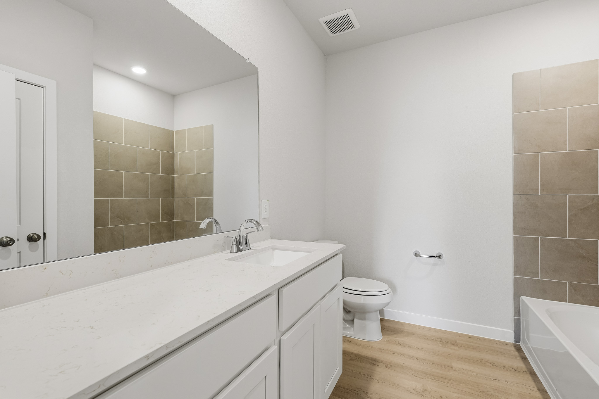 A bathroom with a tub sink and toilet.