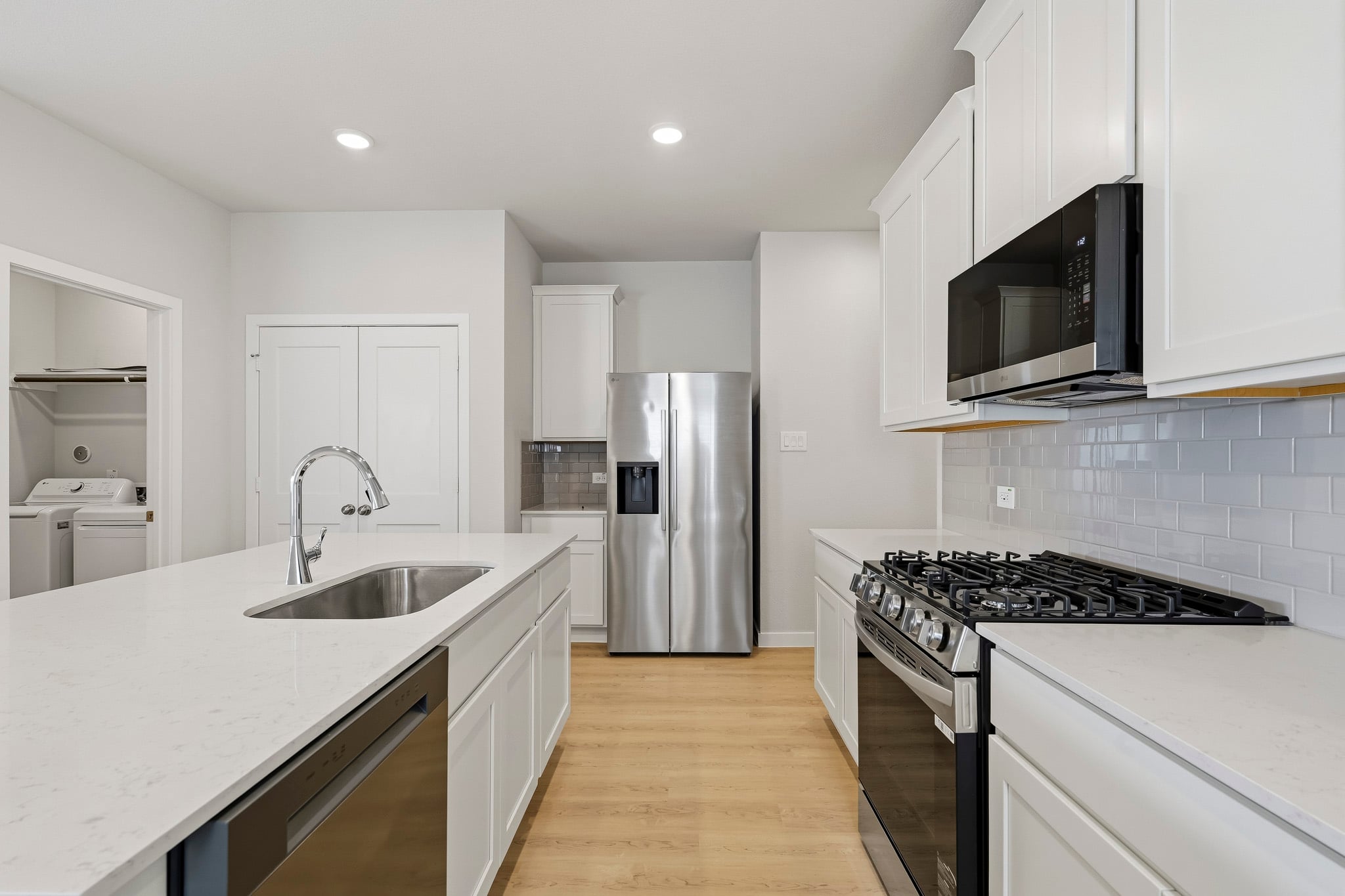 A kitchen with white cabinets.