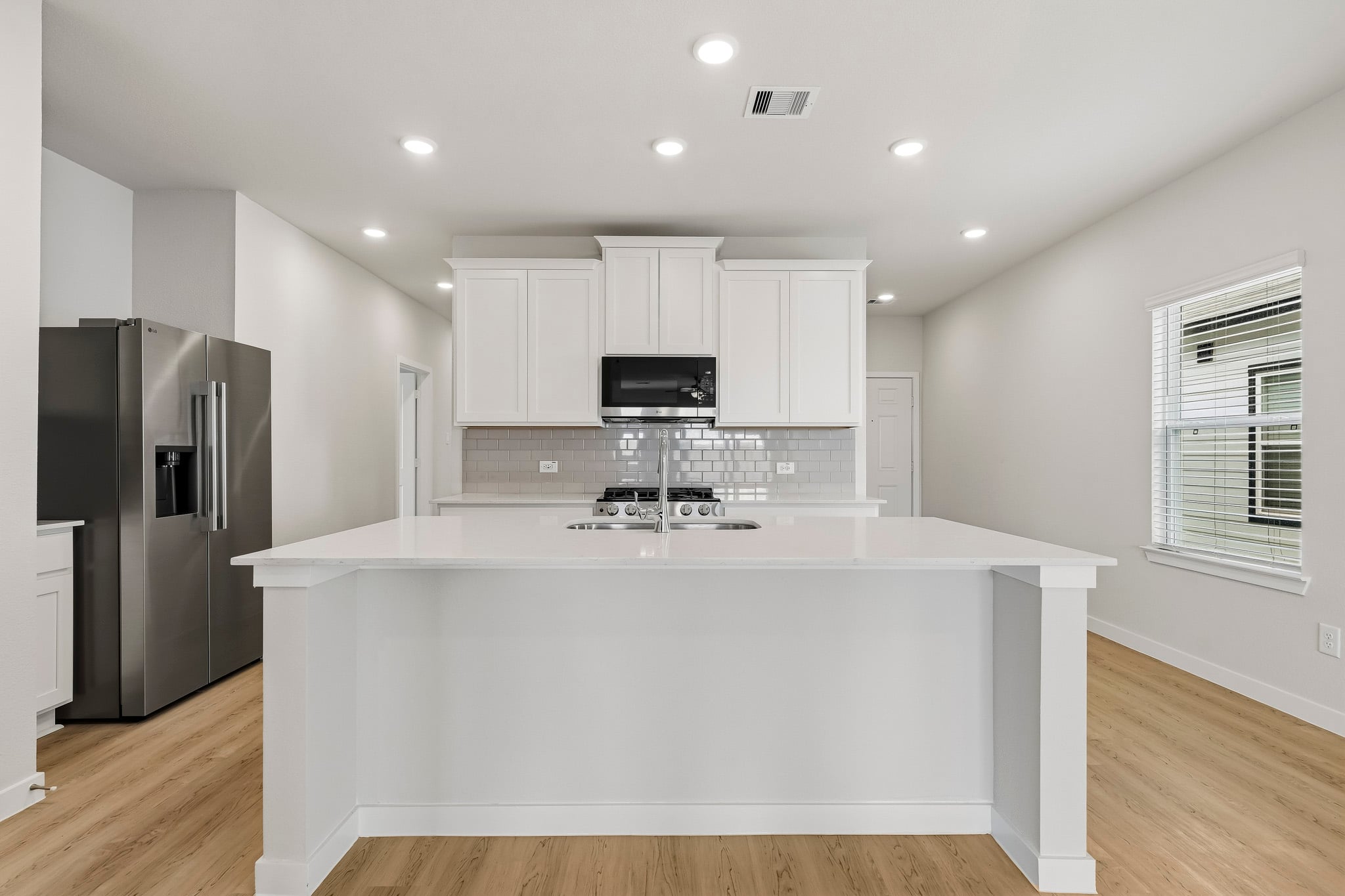 A kitchen with white cabinets.
