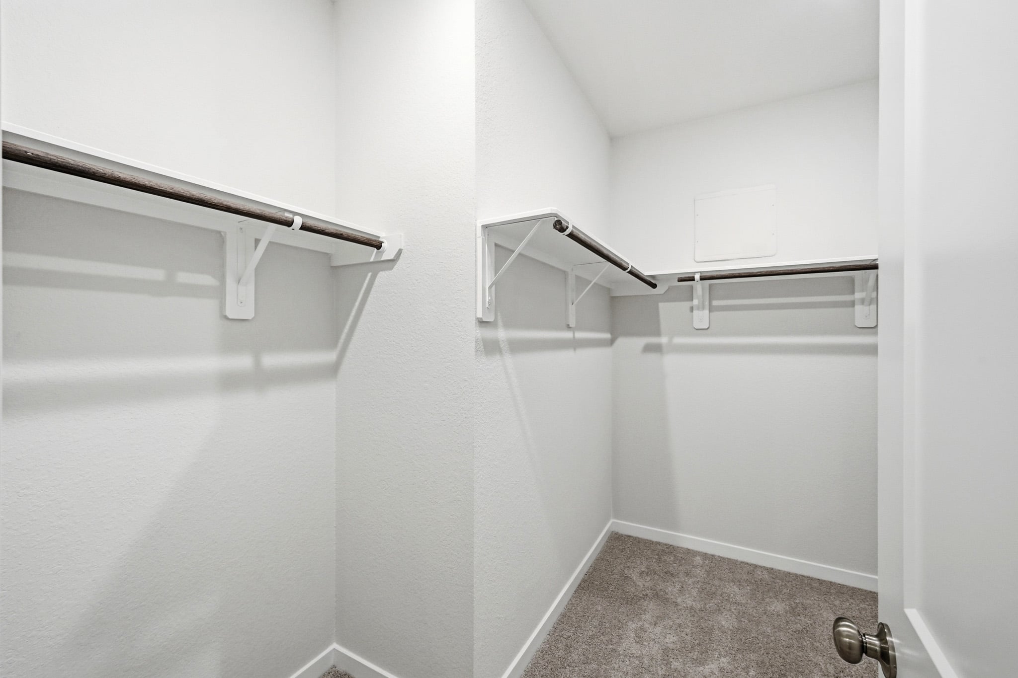 A white wall with a metal bar.