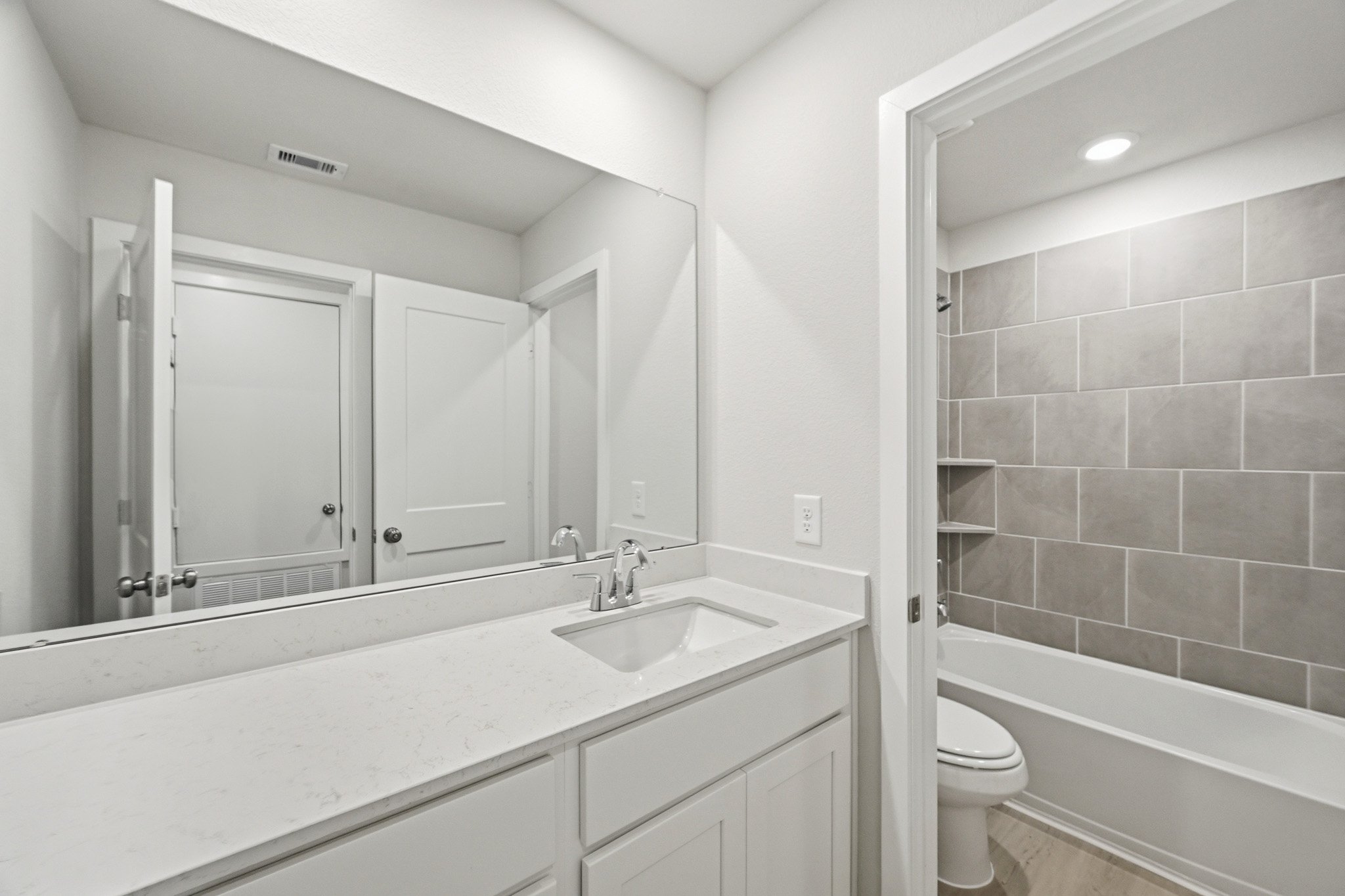 A bathroom with a sink toilet and bathtub.