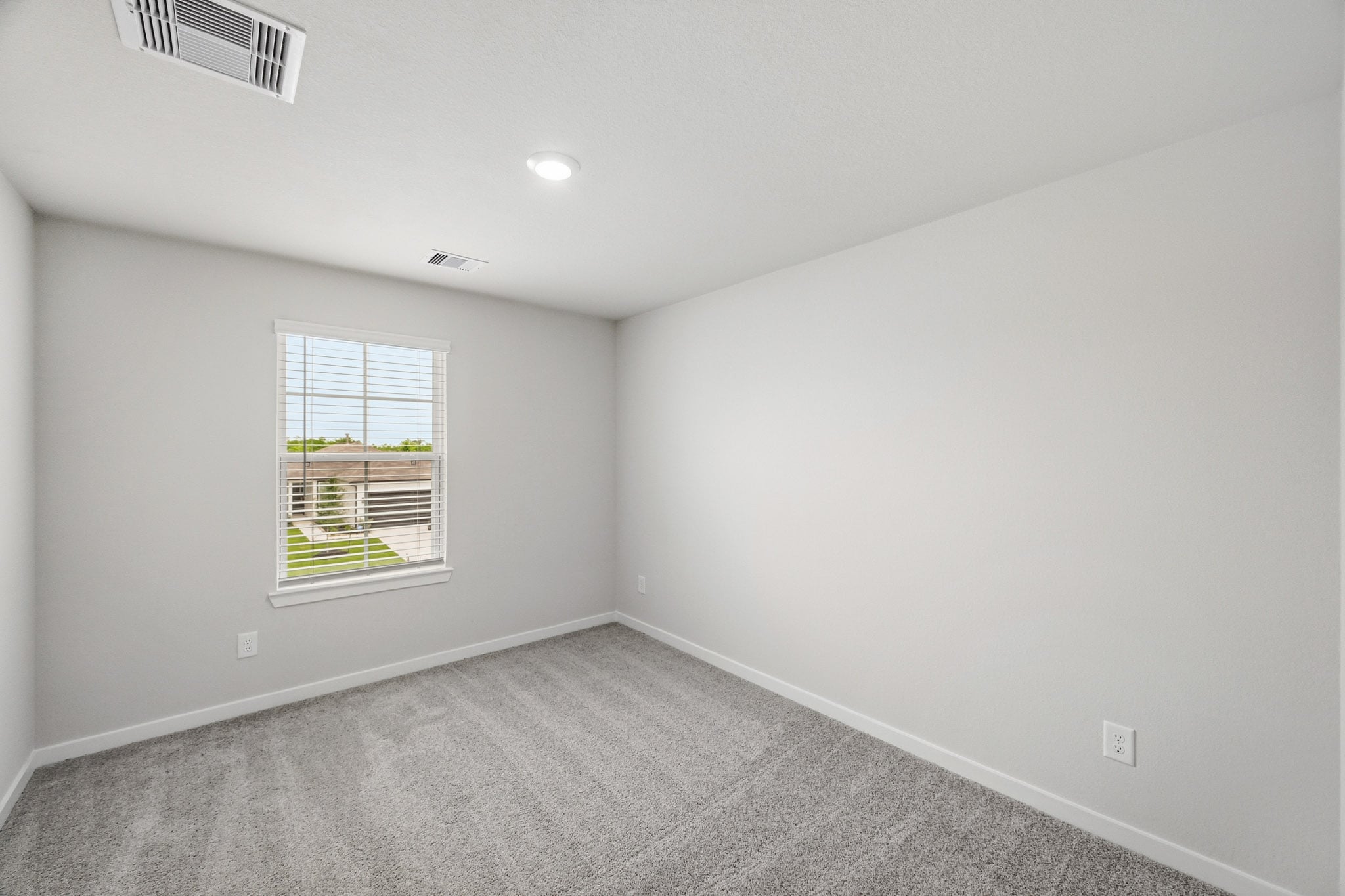 A room with a window and a carpet.