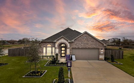 A building with a driveway and a sunset in the background.
