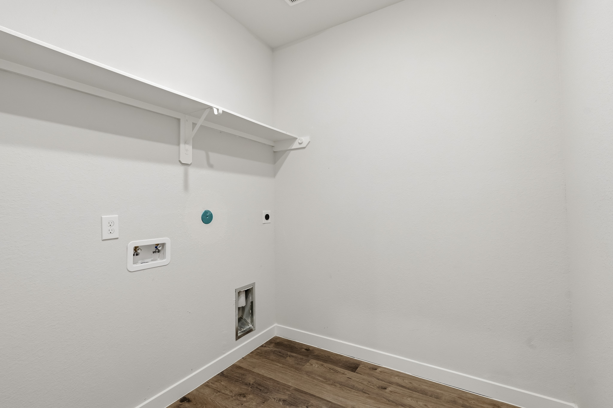 A white room with a wood floor.