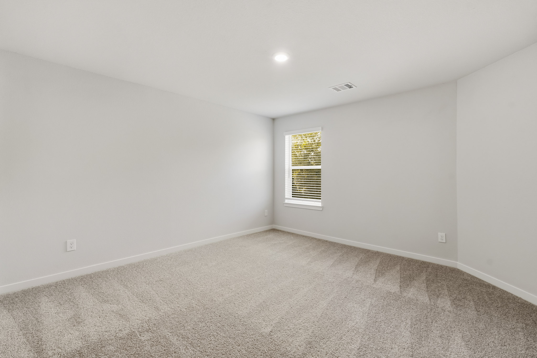 A room with a window and carpet.