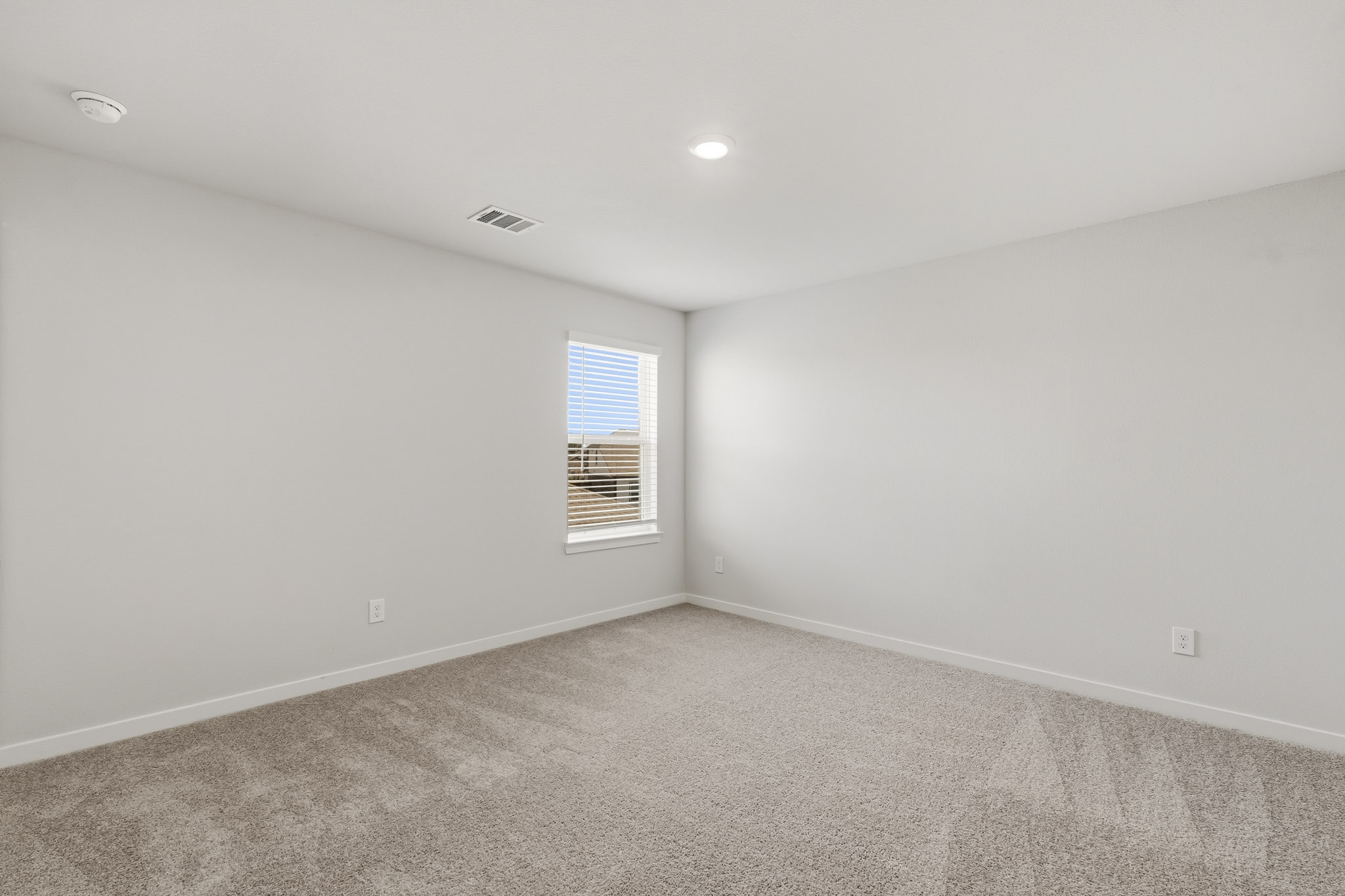 A room with a window and carpet.
