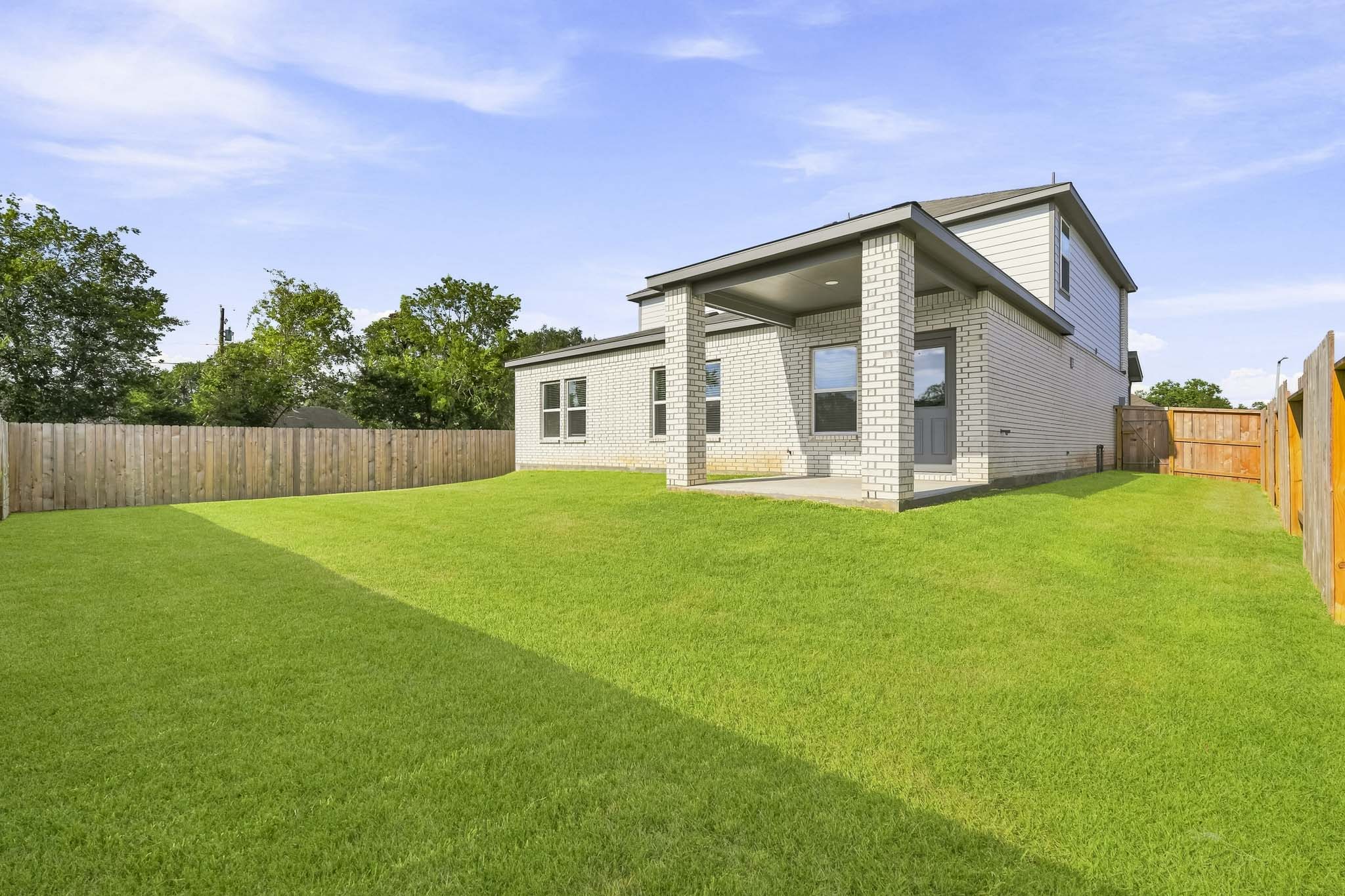 A house with a fence and grass.