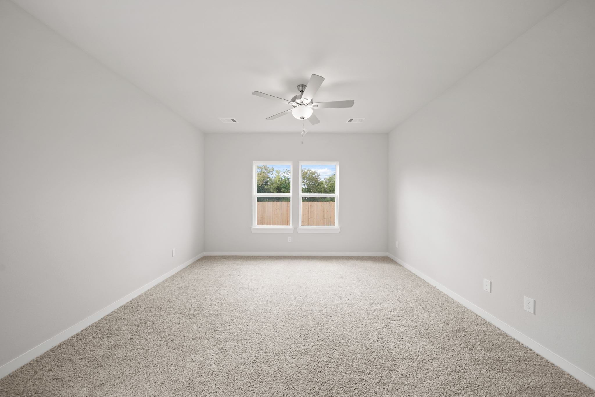 A room with a ceiling fan and a window.
