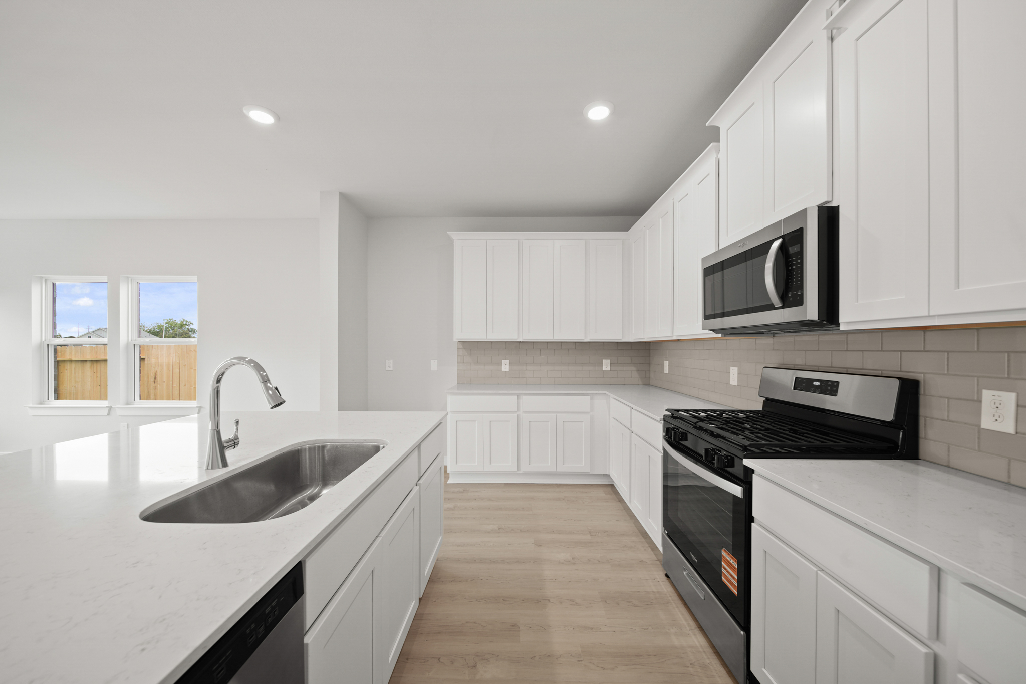 A kitchen with white cabinets.