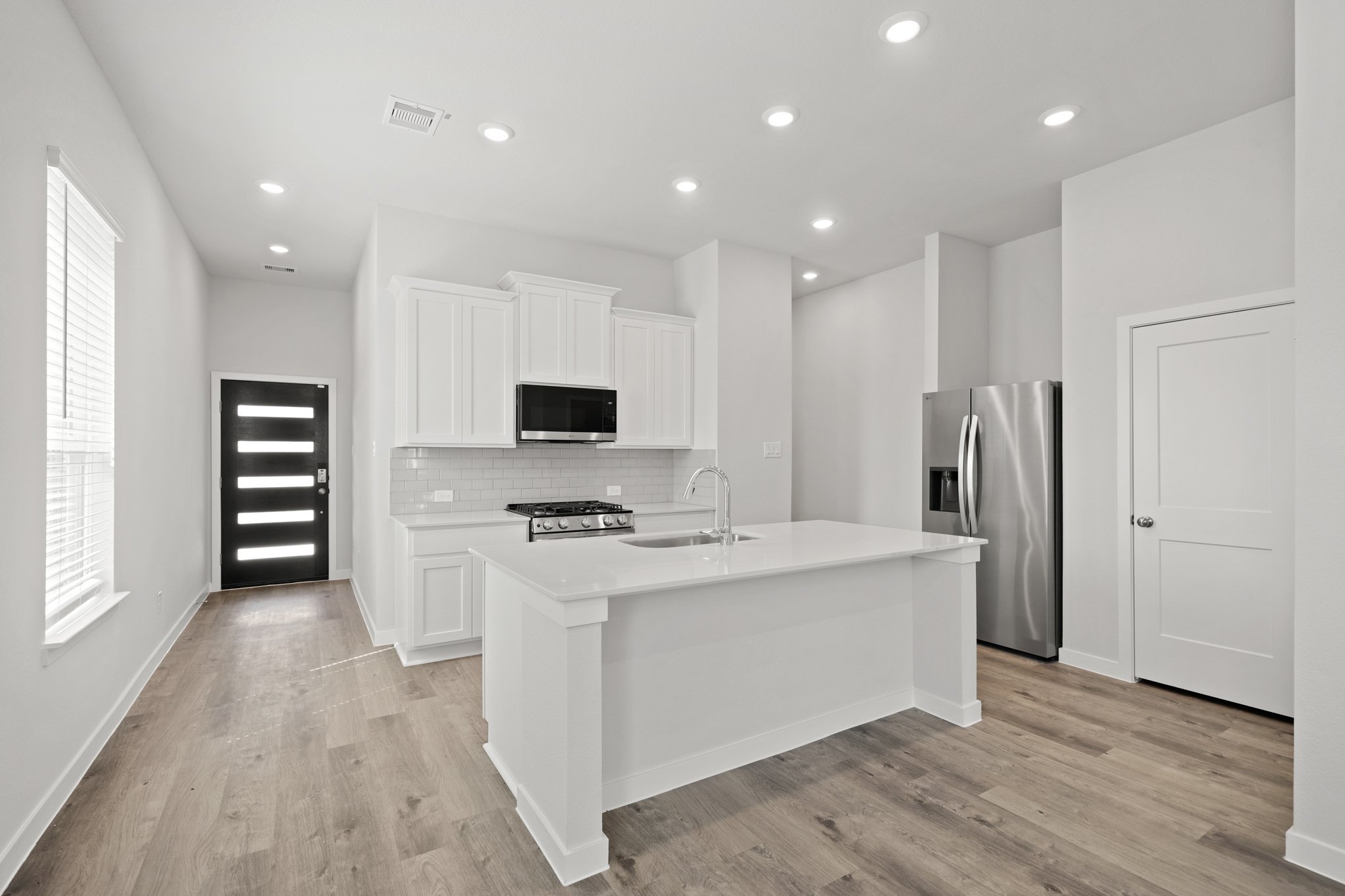 A kitchen with white cabinets.