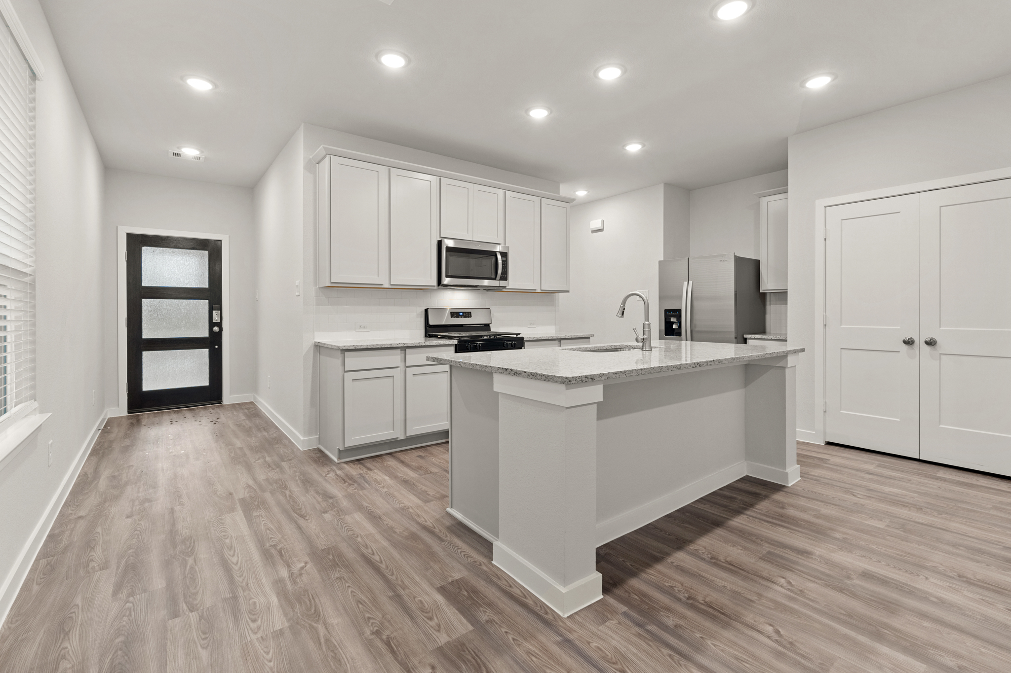 A kitchen with white cabinets.