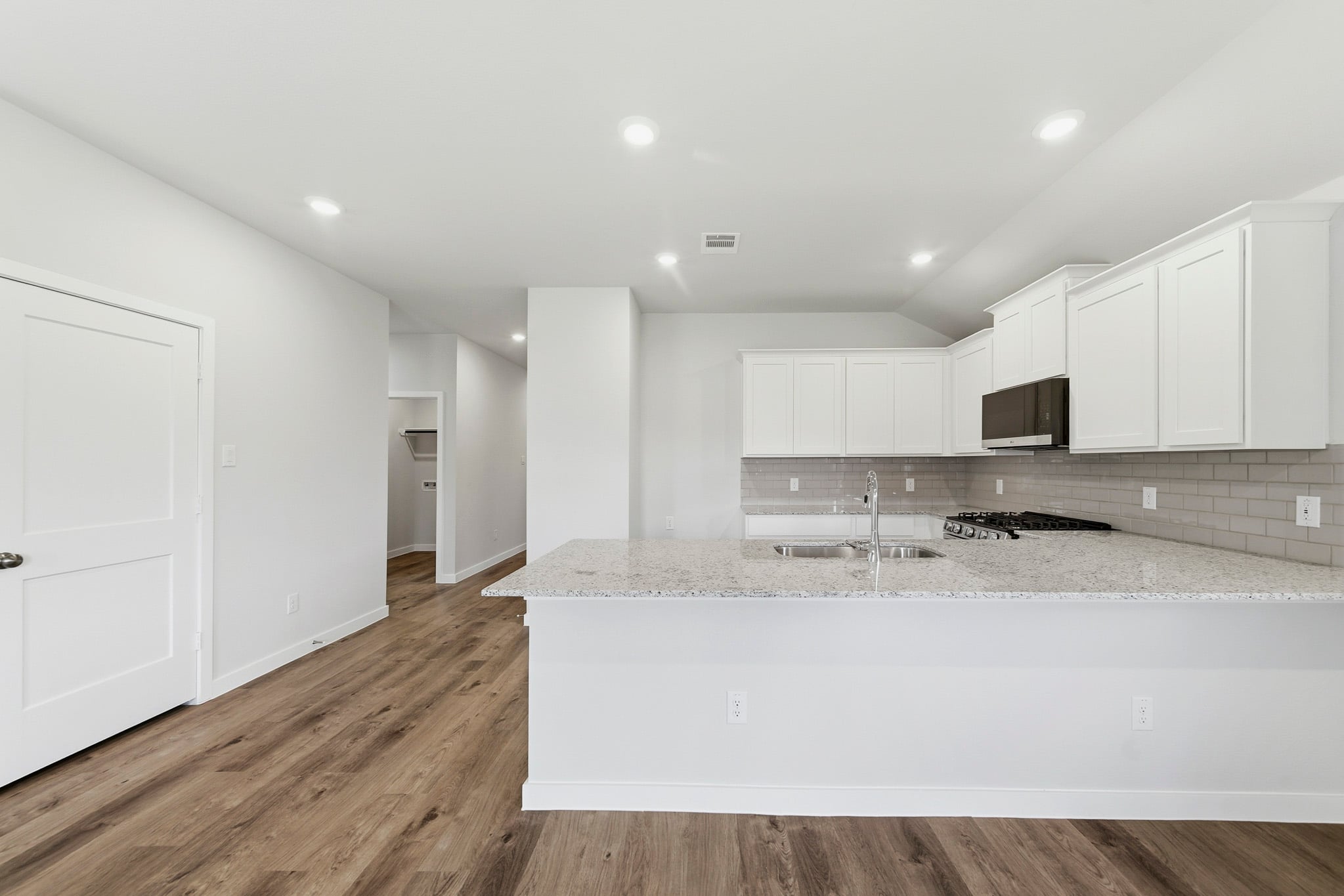 A kitchen with white cabinets.