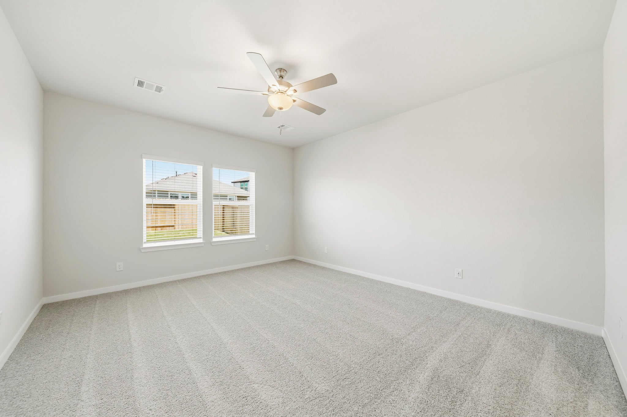 A room with a ceiling fan and a window.