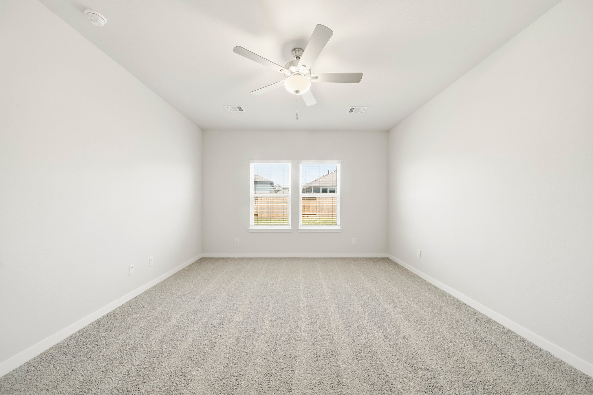 A room with a ceiling fan and a window.