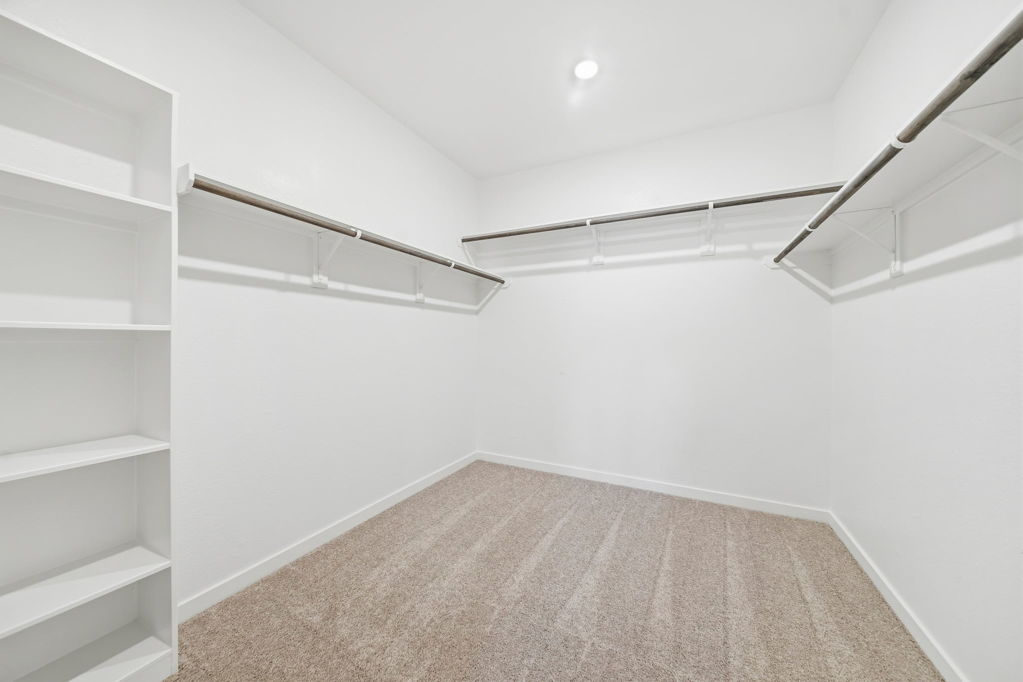 A white room with a carpet and a white wall.