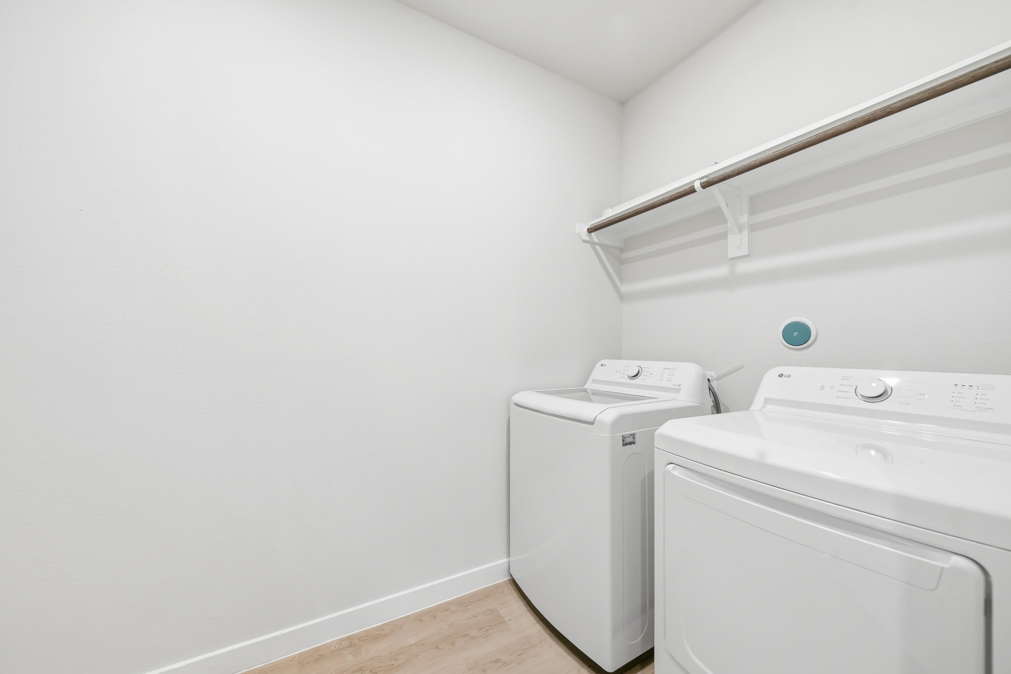 A white laundry room with a white wall.