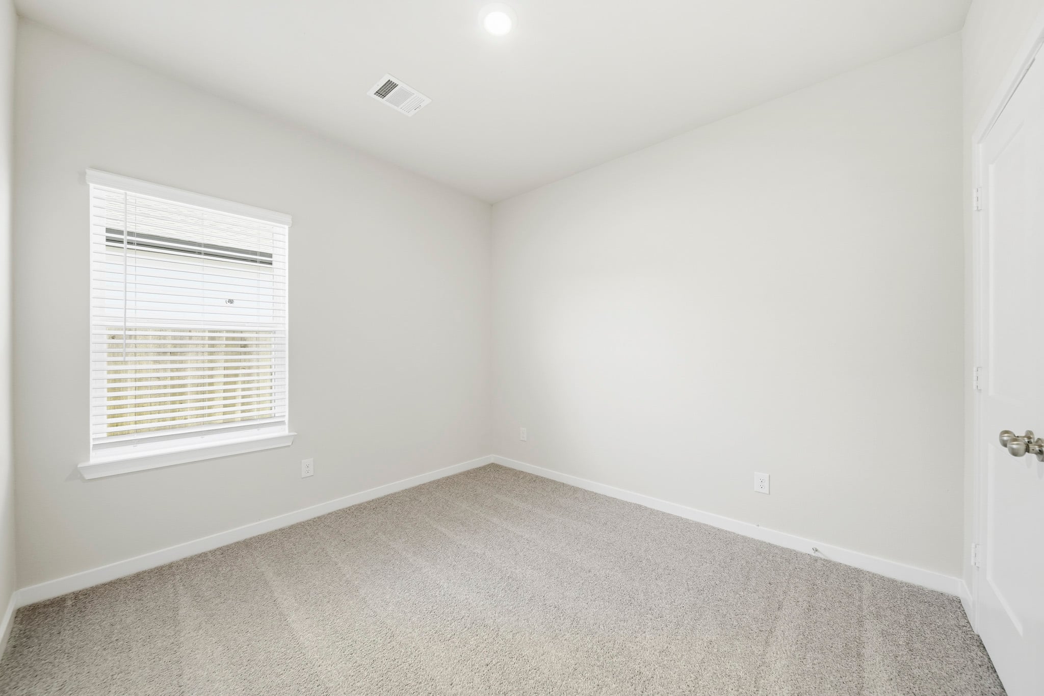 A room with a carpet and a window.