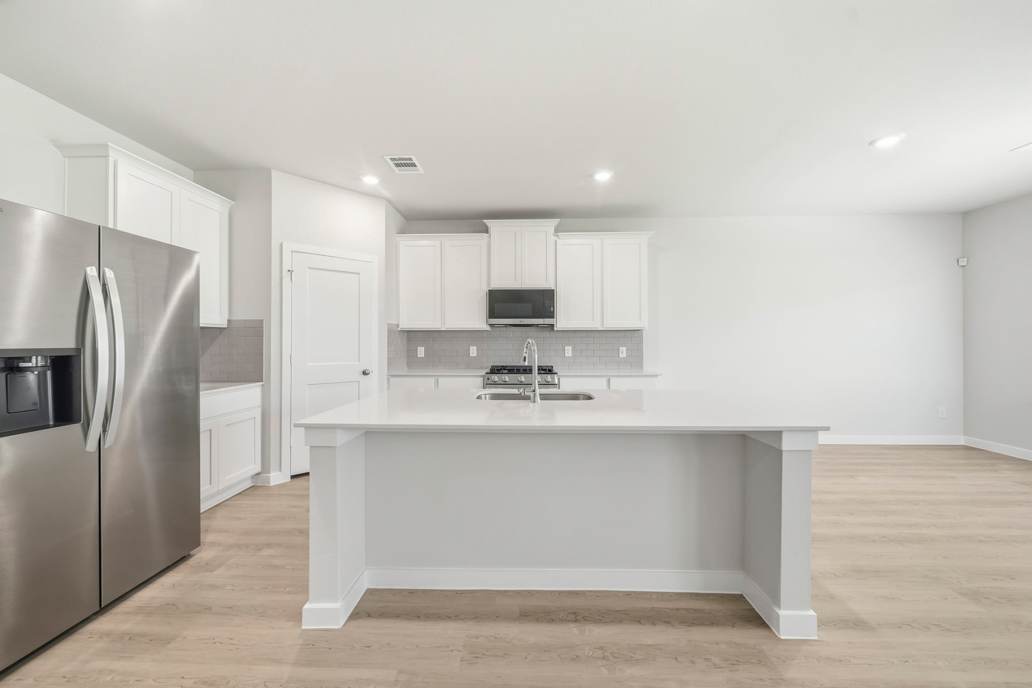 A kitchen with white cabinets.