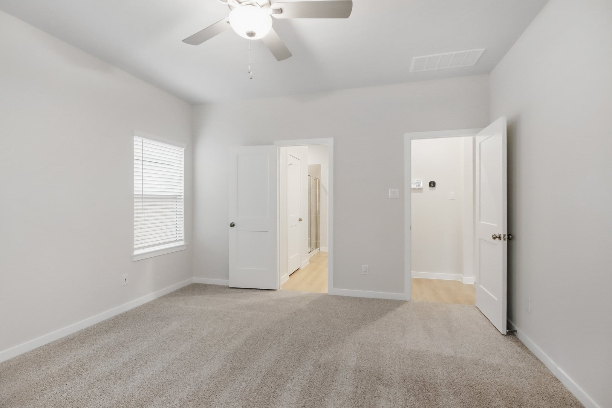 A room with white doors and a ceiling fan.