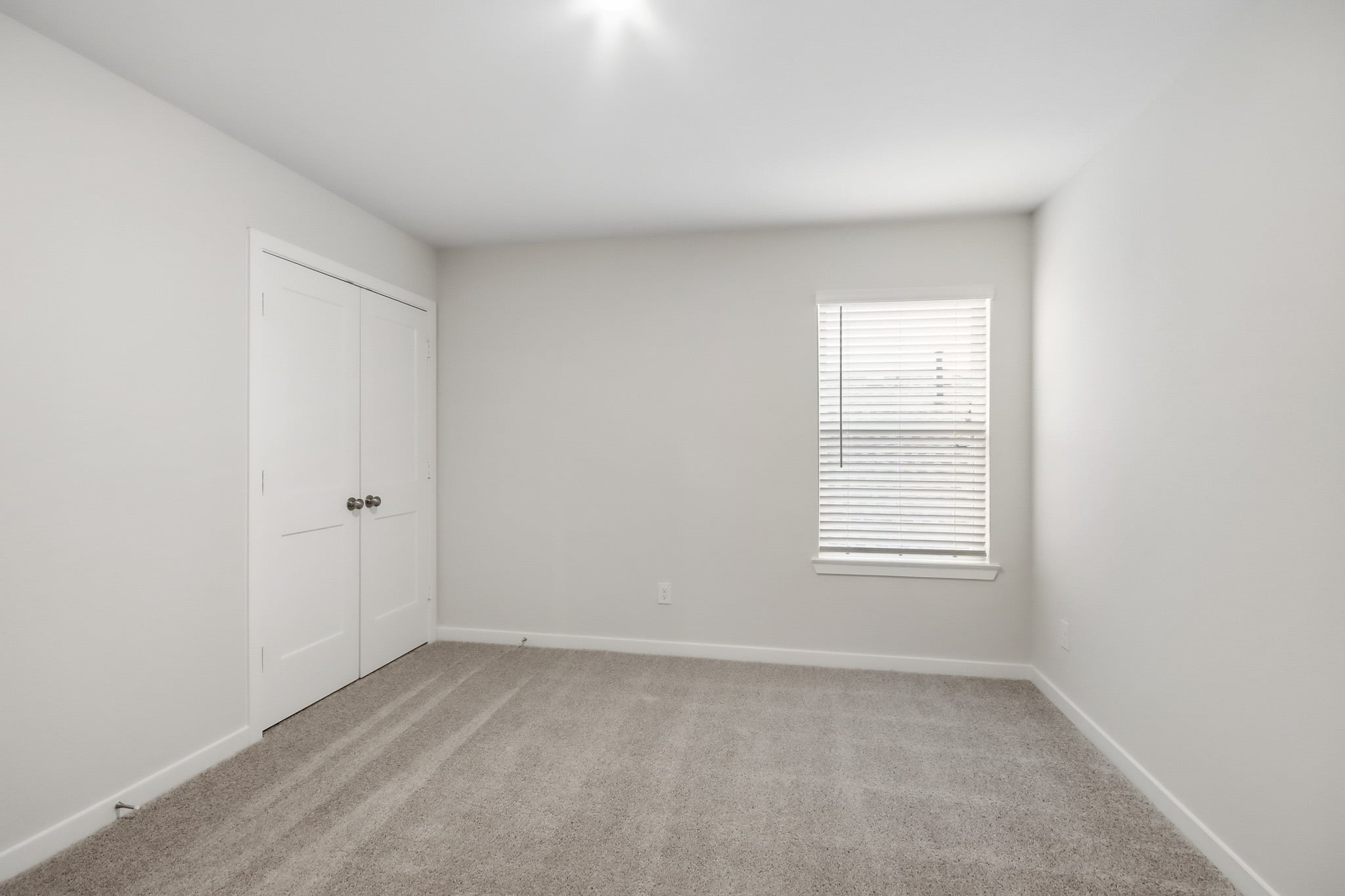 A room with white walls and a window.