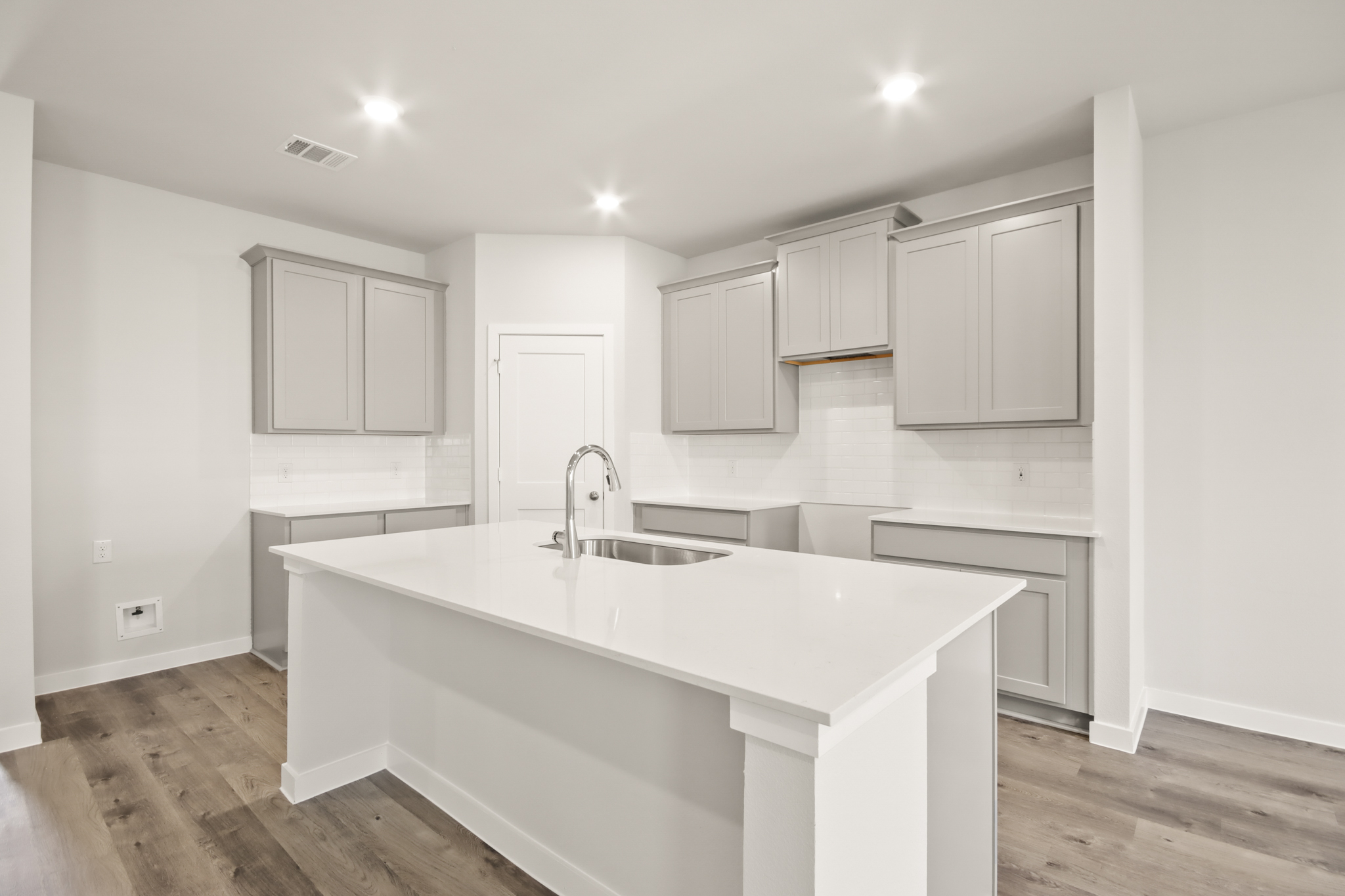 A kitchen with white cabinets.