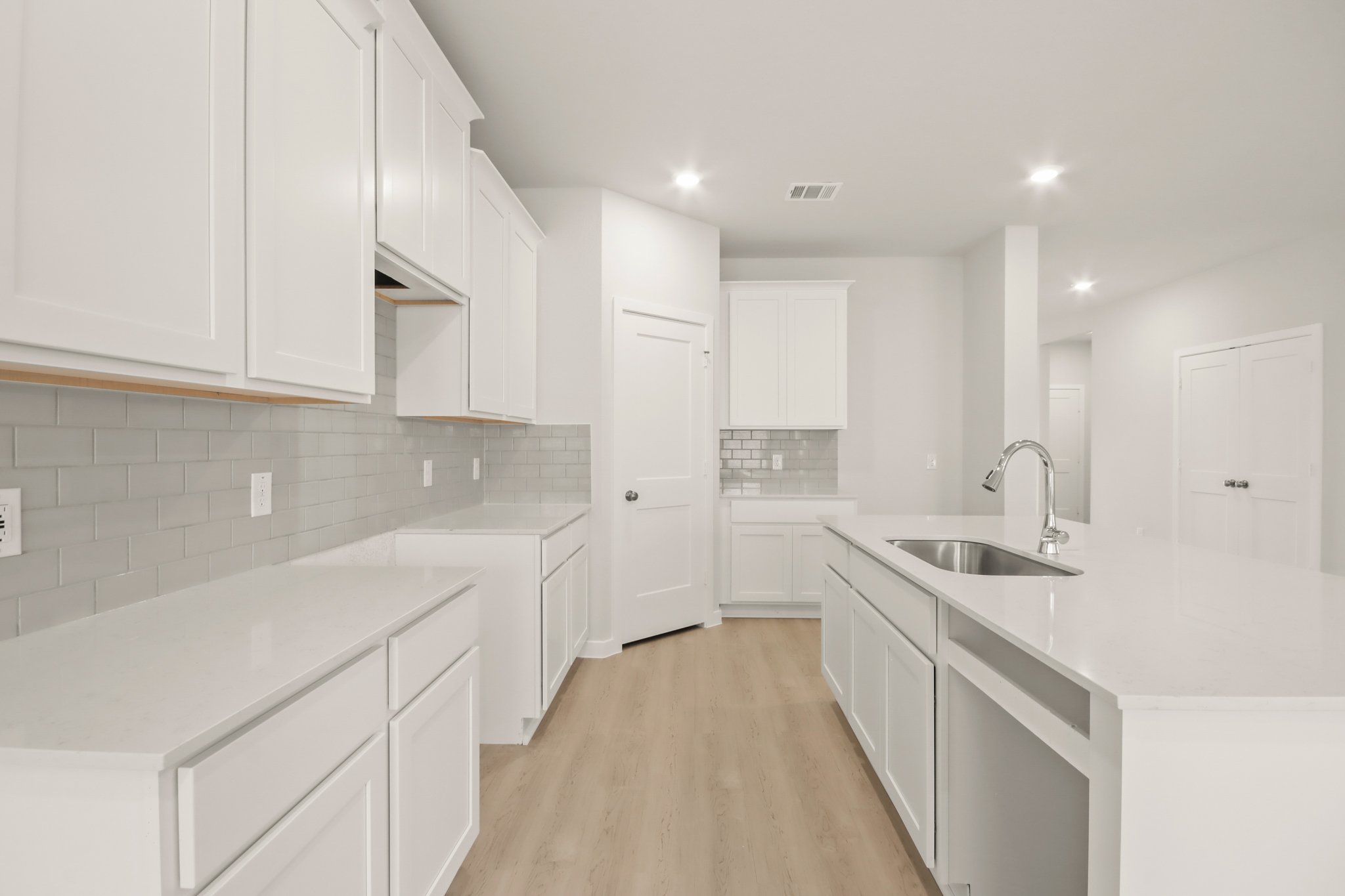 A kitchen with white cabinets.