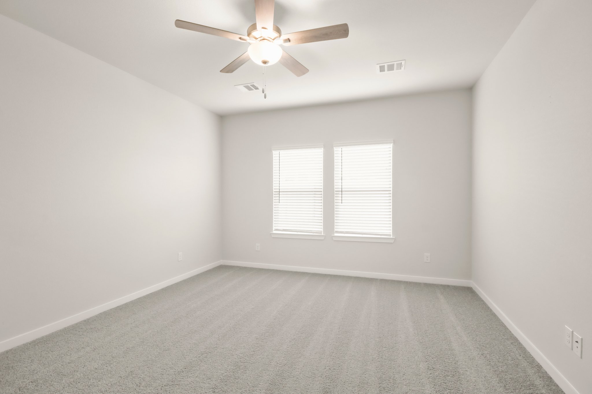 A room with a ceiling fan and a window.