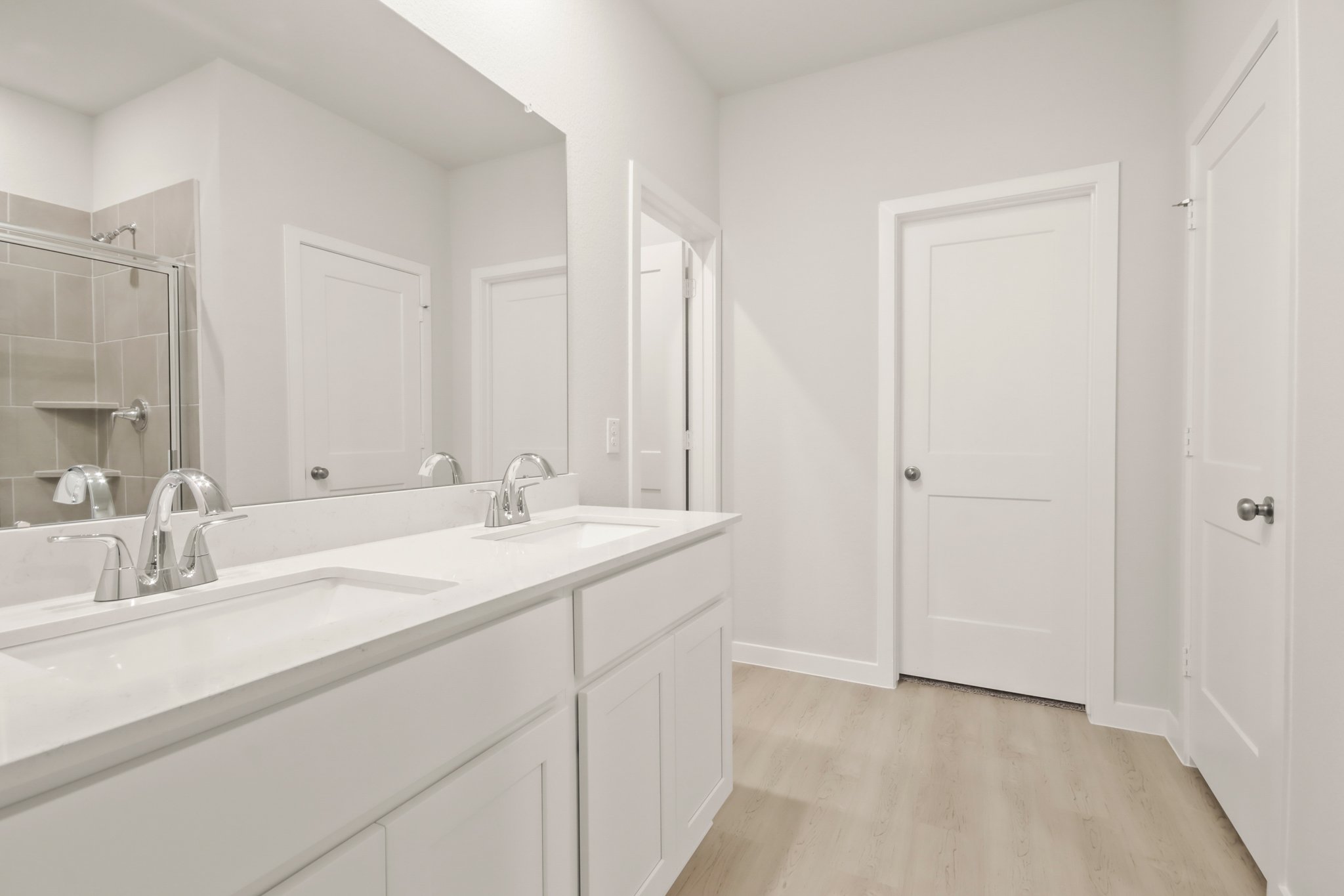 A bathroom with white cabinets.