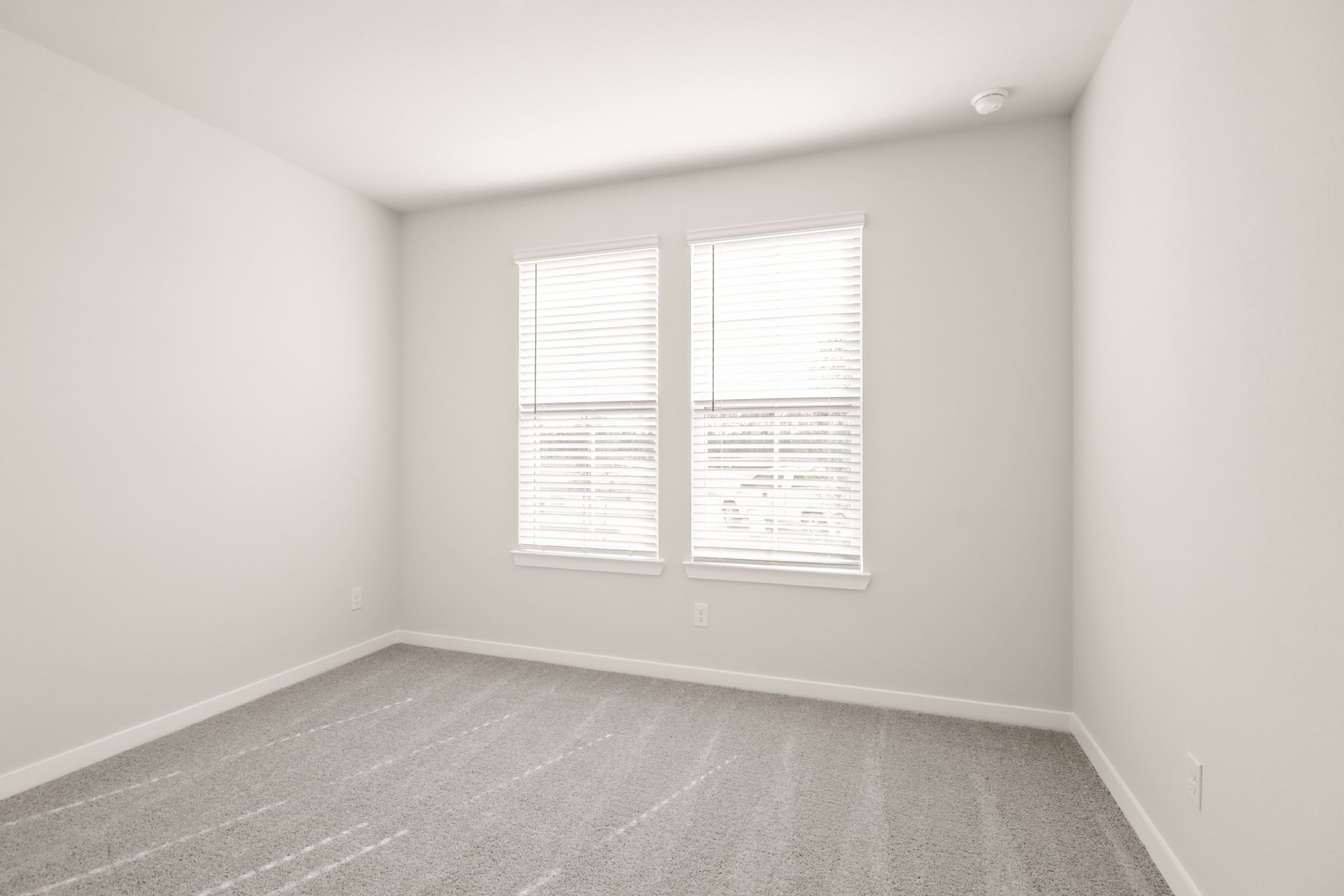 A room with a window and a rug.