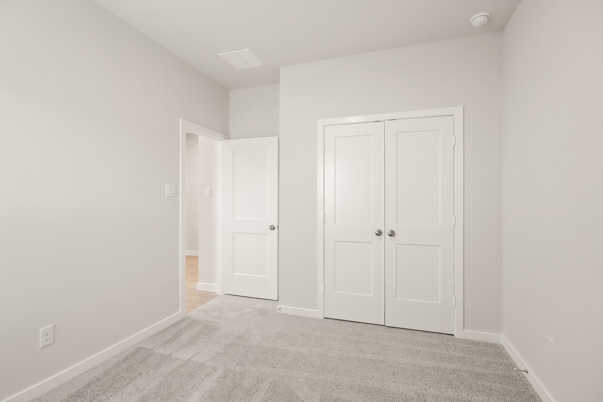 A hallway with white doors.