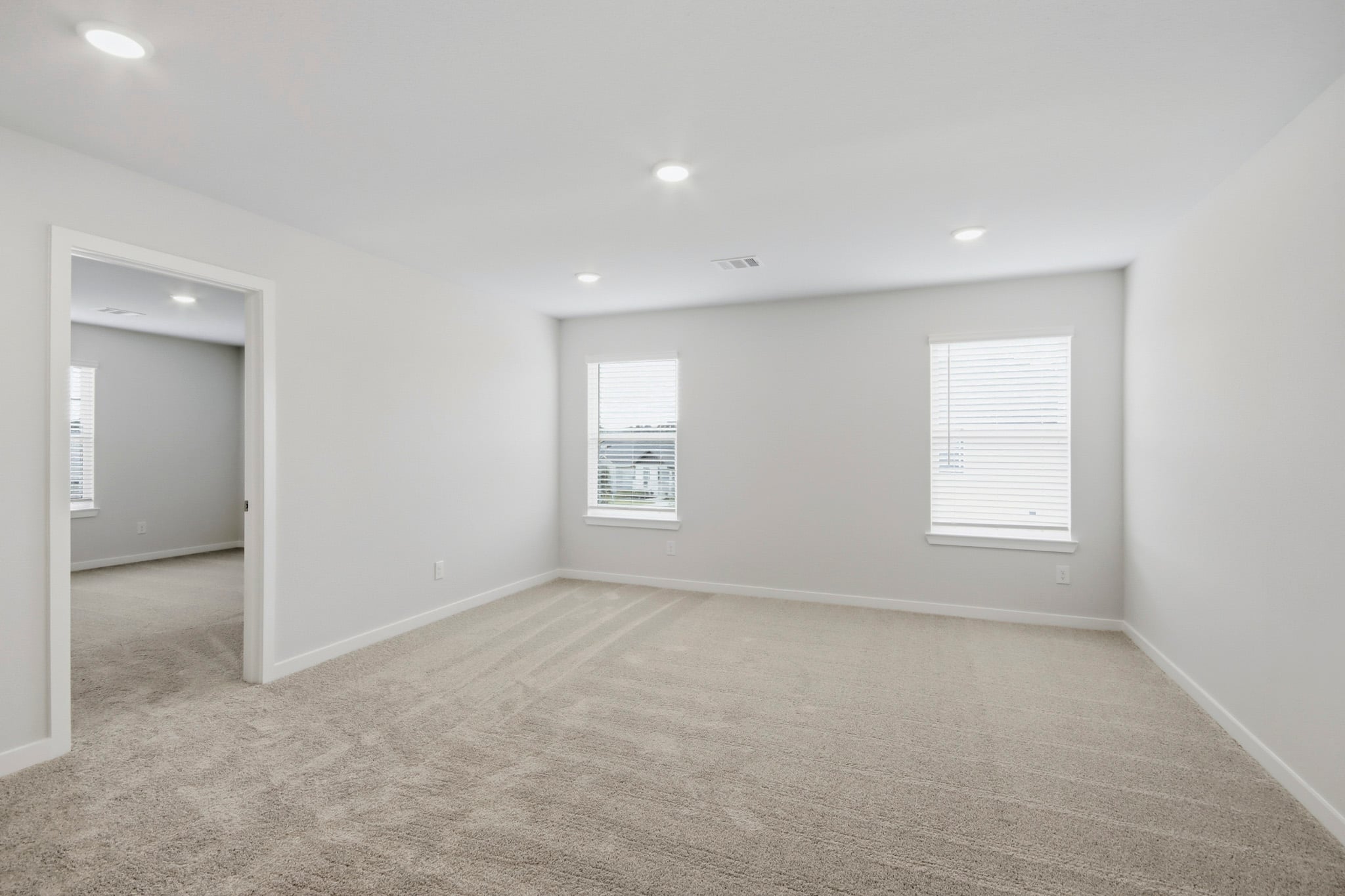 A room with a carpet and a door.