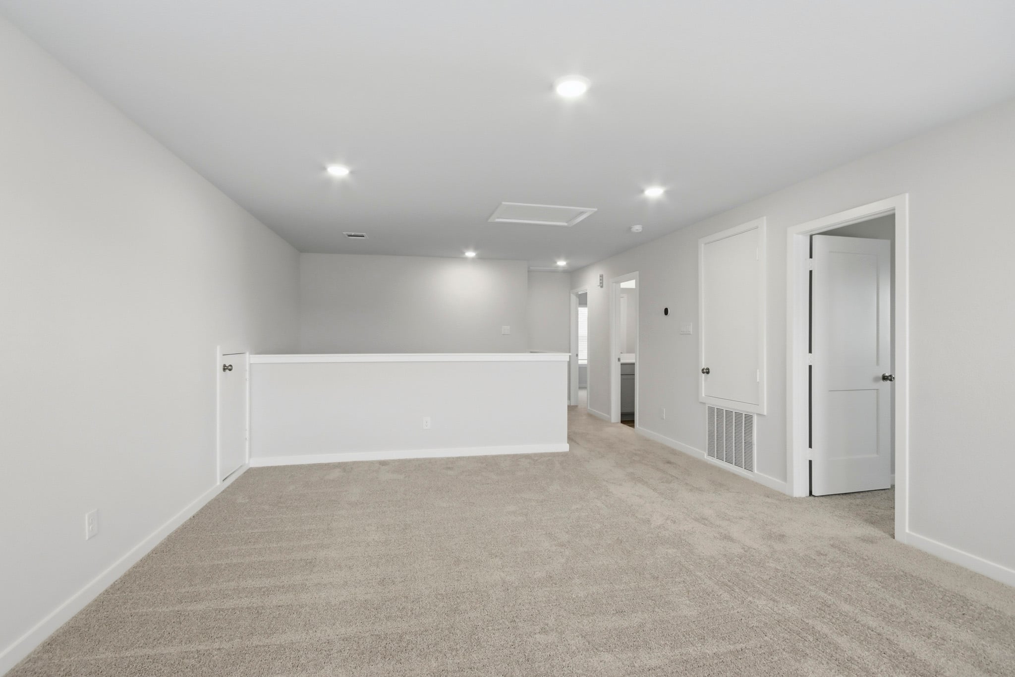 A long hallway with white doors.