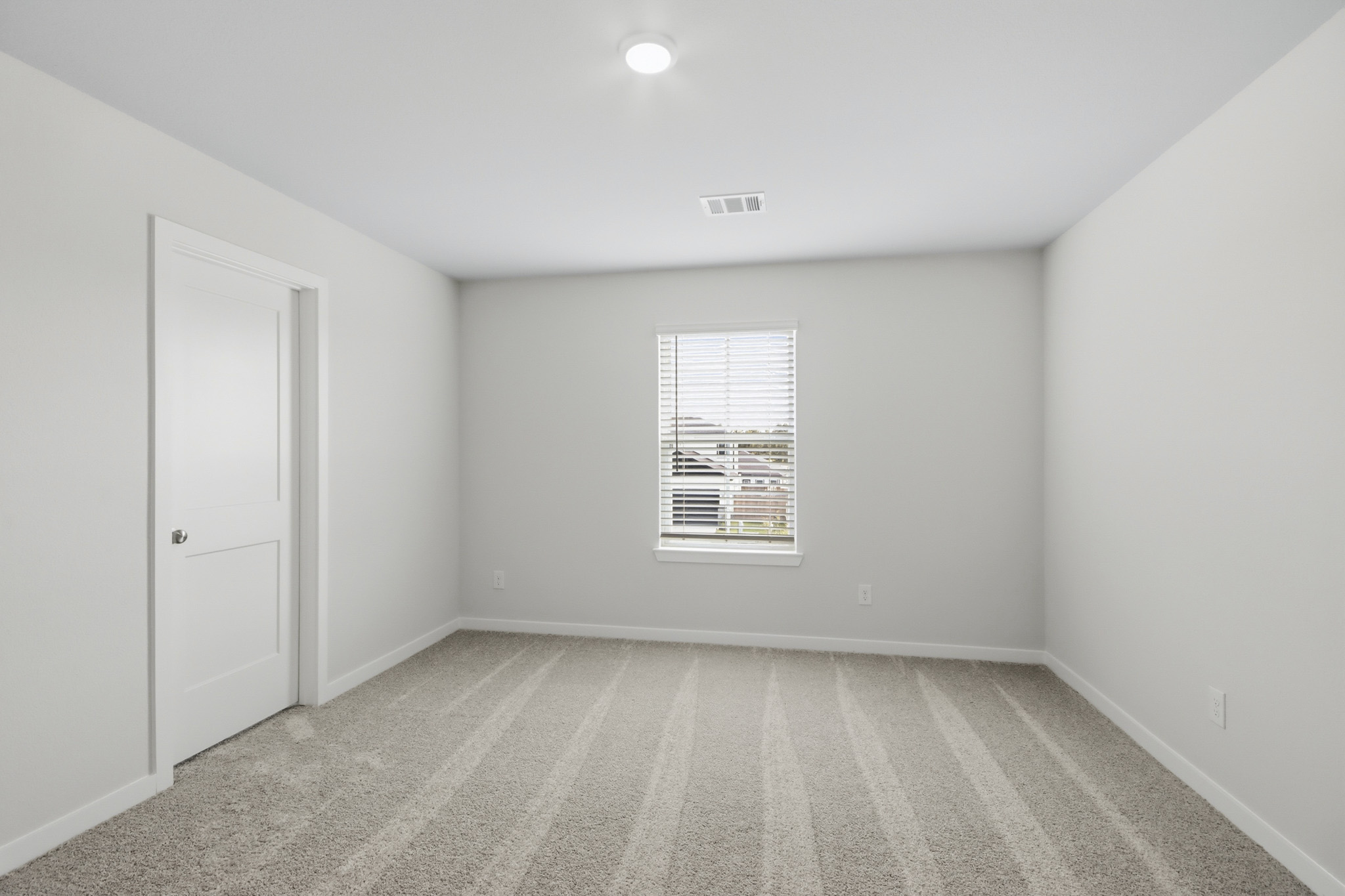A room with white walls and a door with a window.
