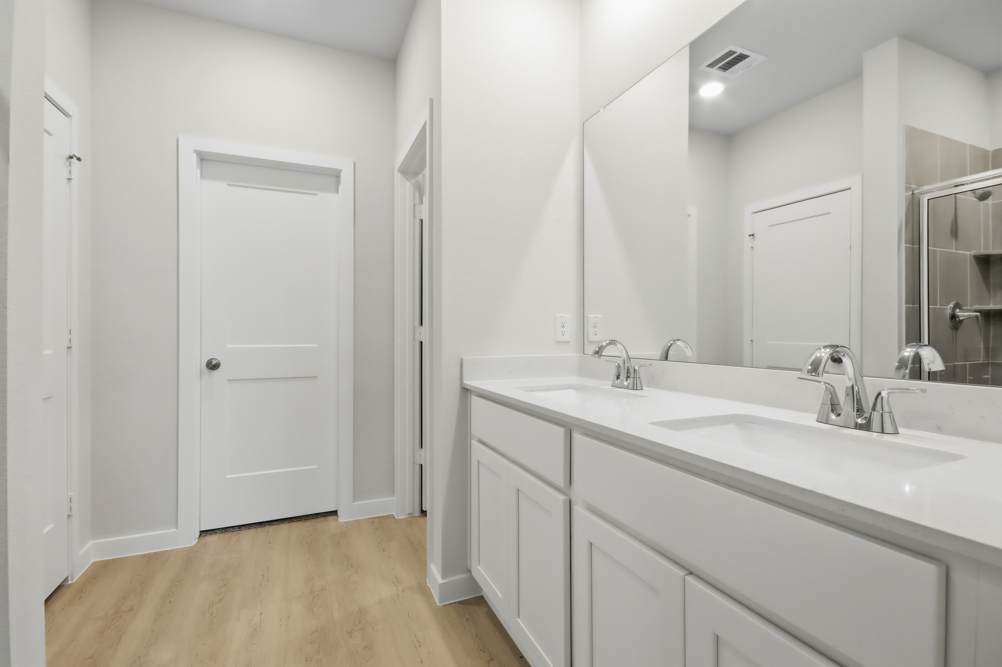 A bathroom with white cabinets.