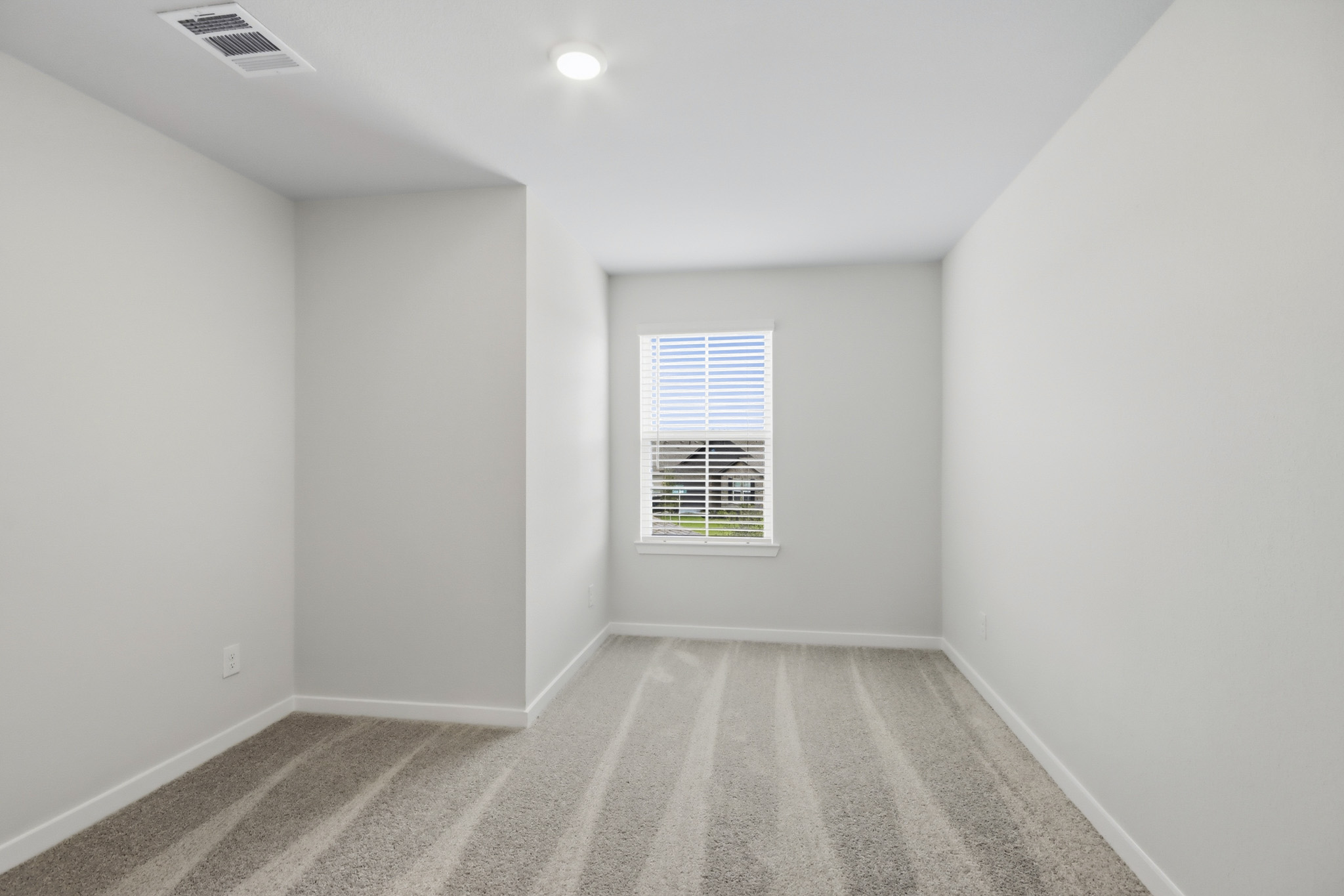 A room with a carpet and a window.
