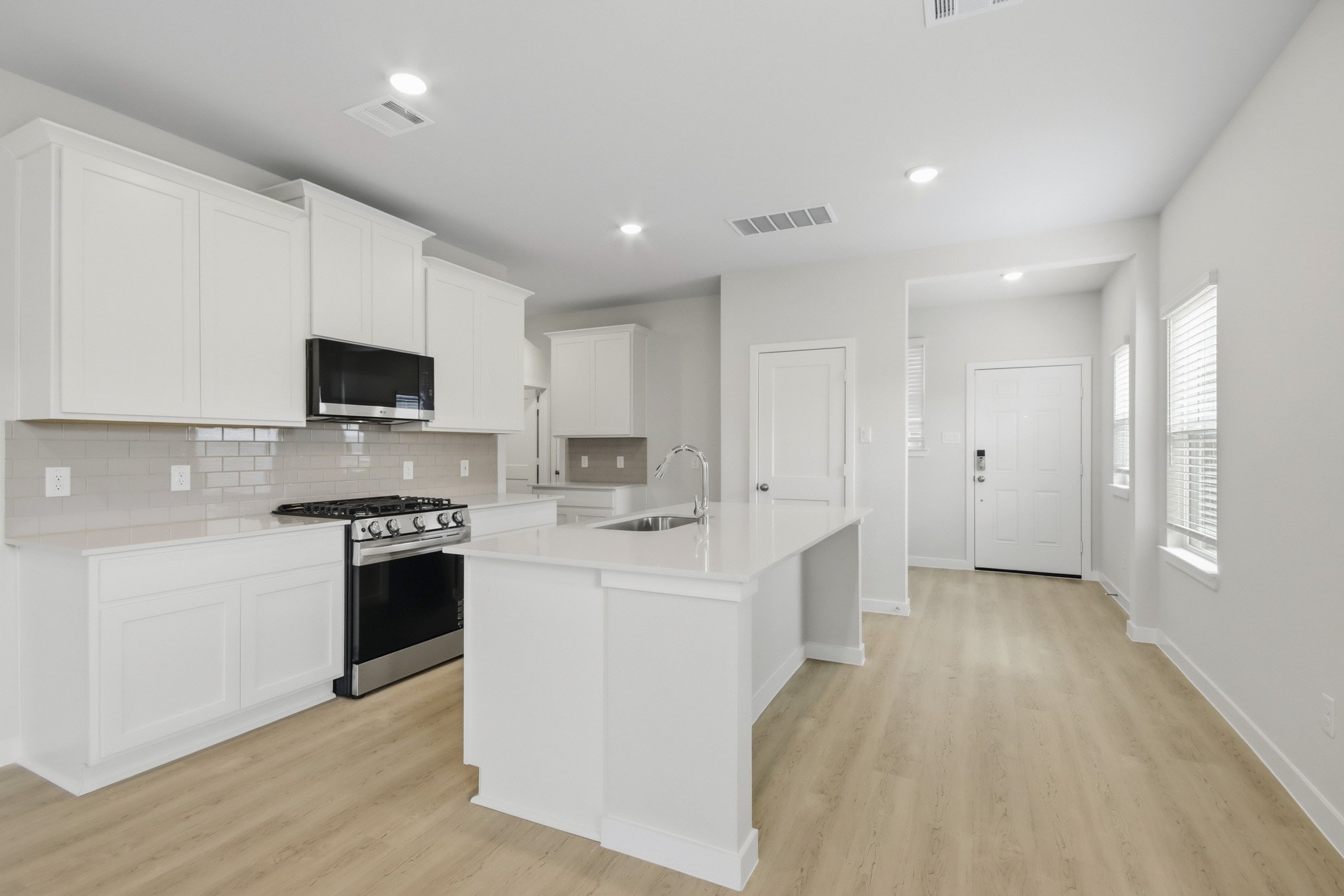 A kitchen with white cabinets.