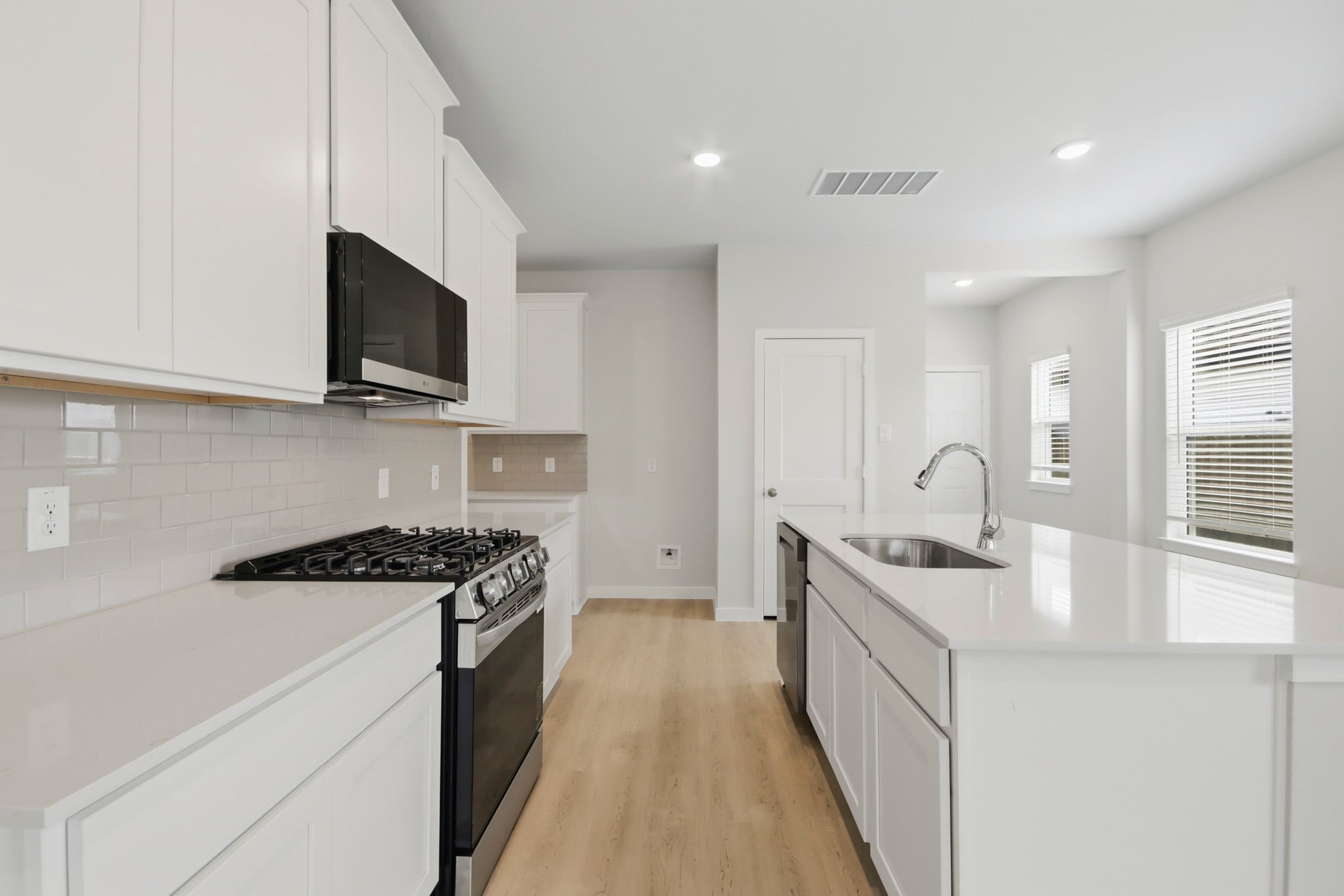 A kitchen with white cabinets.