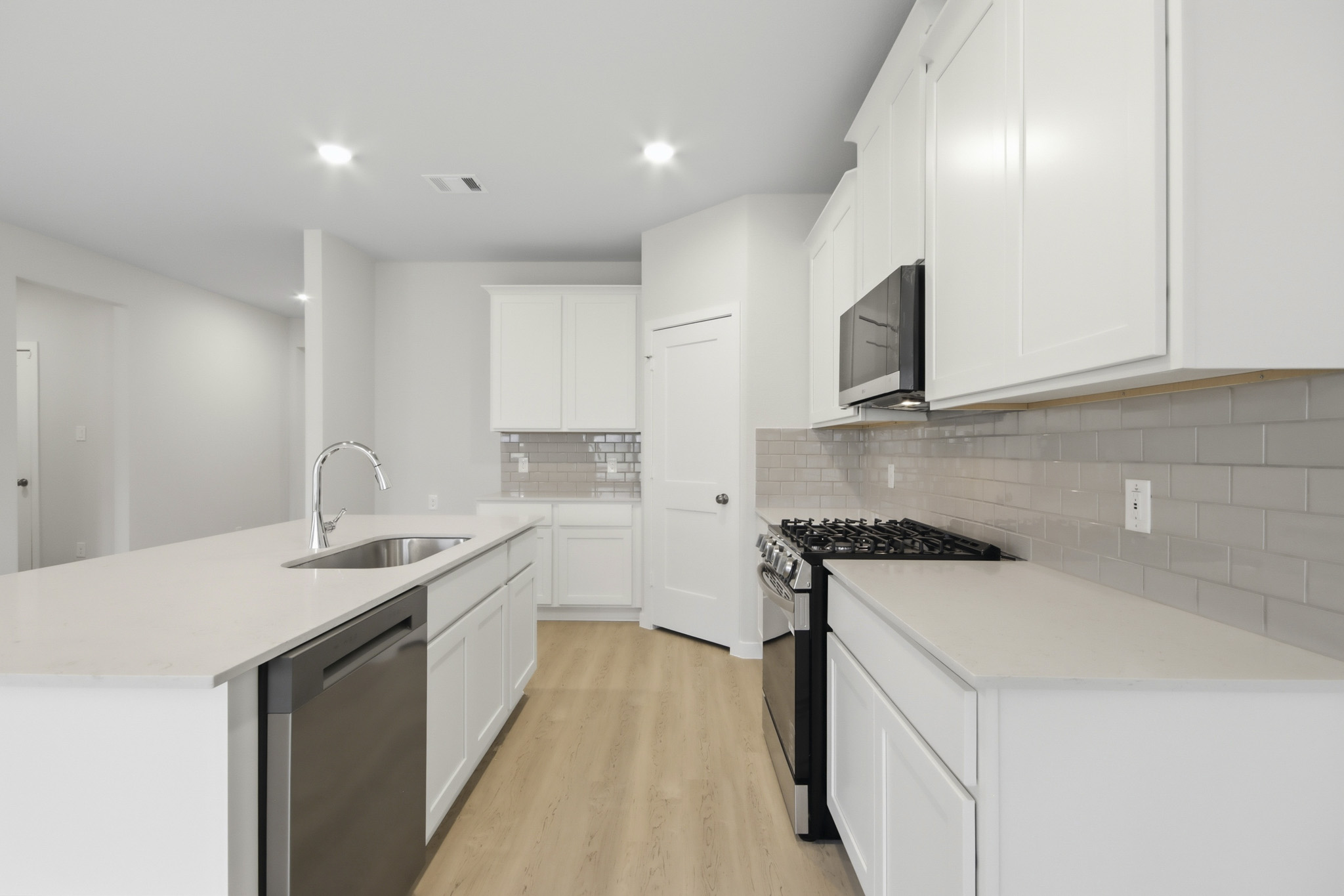 A kitchen with white cabinets.